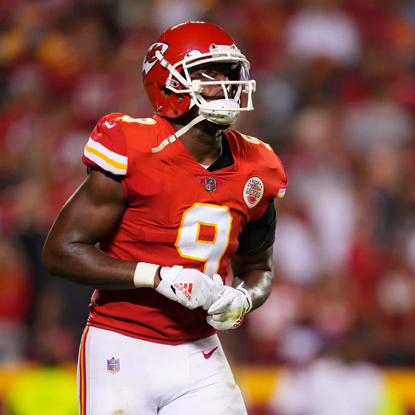 Juju Smith Schuster 桌布 壁紙 — 一位身穿紅色九號球衣的堪薩斯城酋長隊美式足球員在球場燈光下專注地站在場上。