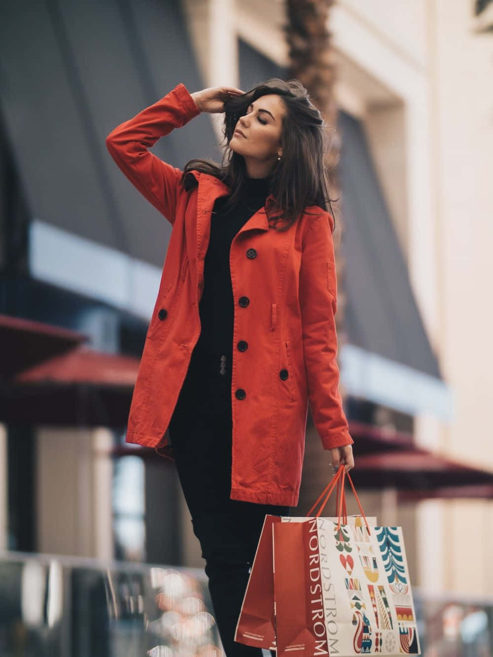 一位身穿紅色外套、手持購物袋的女性 壁紙