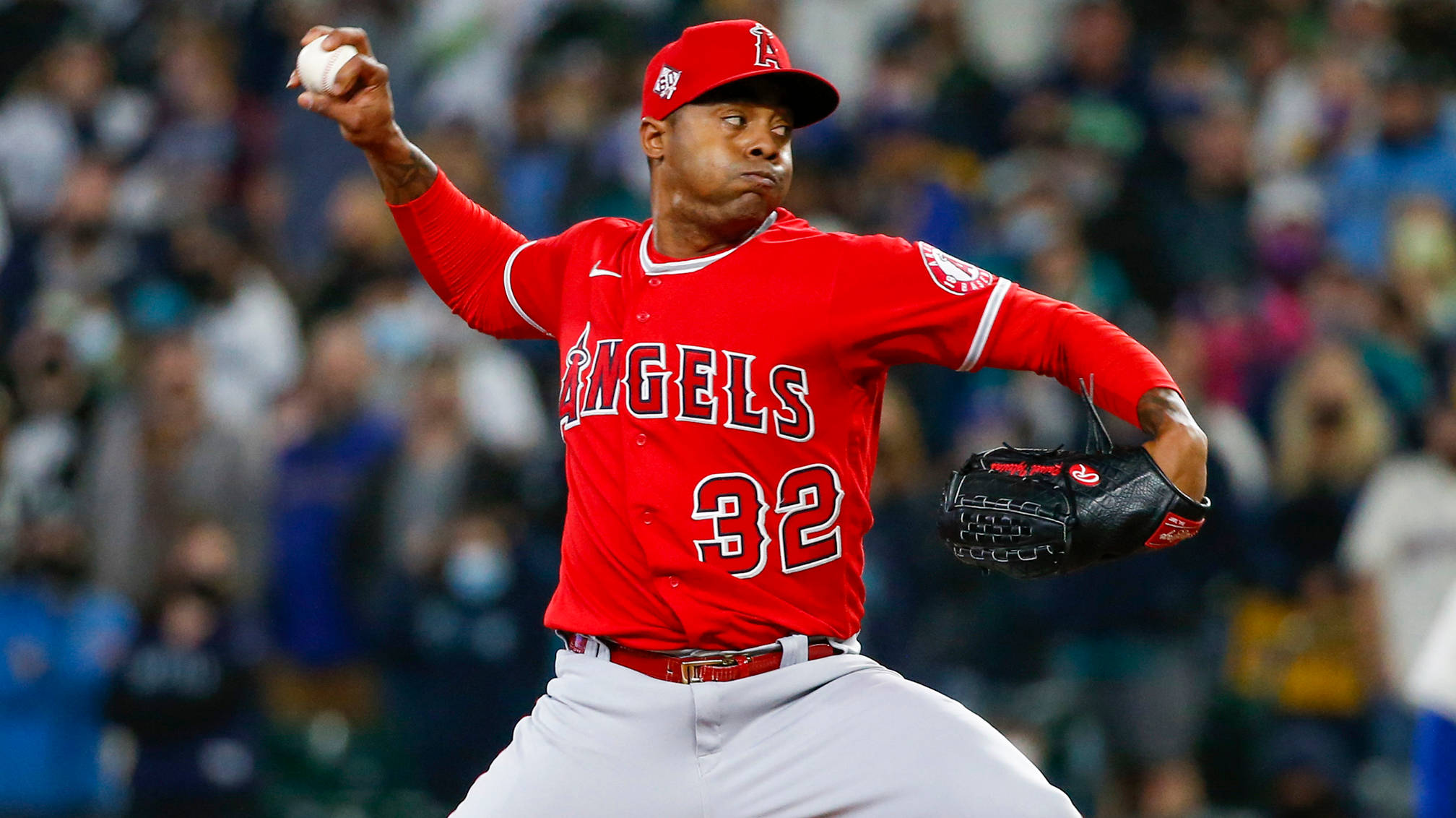 Raisel Iglesias Angels 32 壁紙 — 一位身穿紅色天使隊球衣的棒球投手在球場燈光下準備投球，身後是模糊的人群。