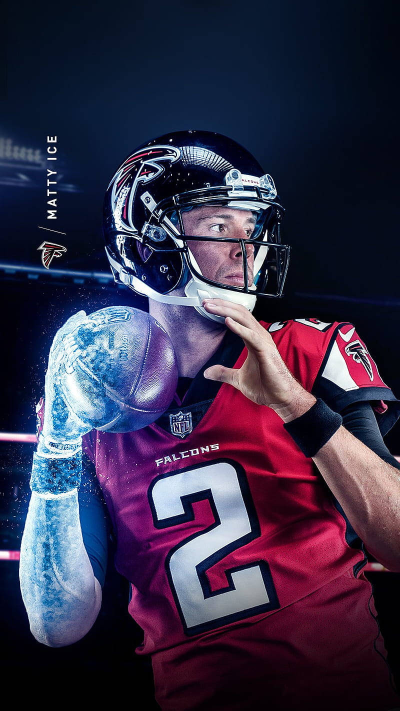 Matt Ryan 桌布 壁紙 — 一位身穿紅色獵鷹隊球衣的美式足球四分衛在戲劇性的藍色燈光下拿著一個發光的美式足球。