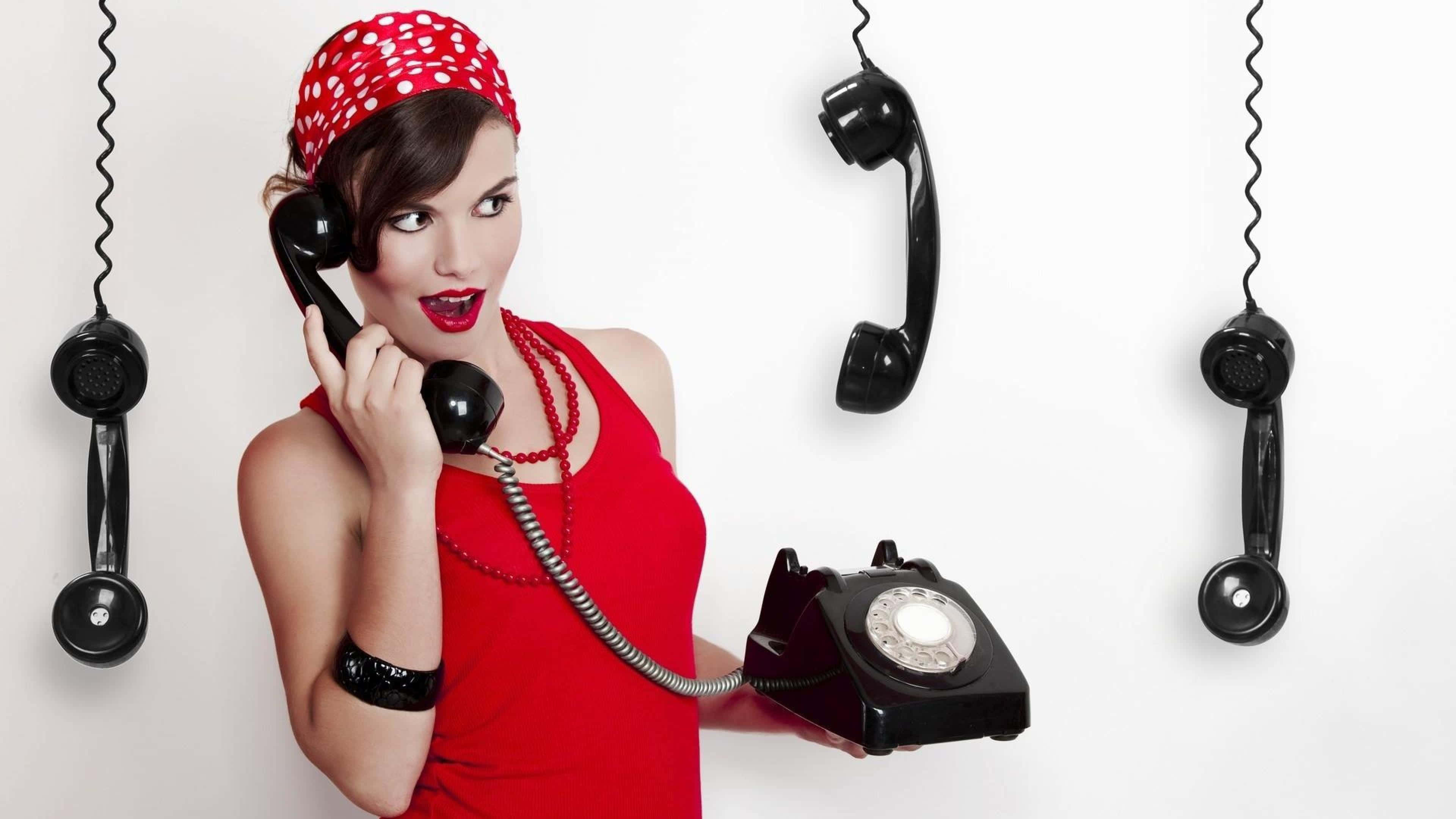 Phone Call 桌布 壁紙 — 一位身穿紅色連衣裙和圓點頭巾的女性拿著一部復古轉盤電話，另外三個聽筒神秘地懸掛在她周圍。