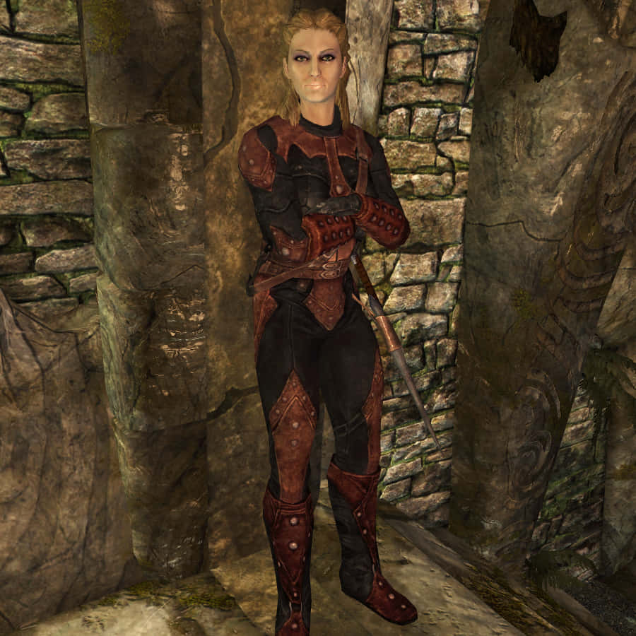 Skyrim Astrid 桌布 壁紙 — 一位身穿紅黑盔甲的女戰士自信地站在長滿青苔的石頭走廊中，手持一把劍。