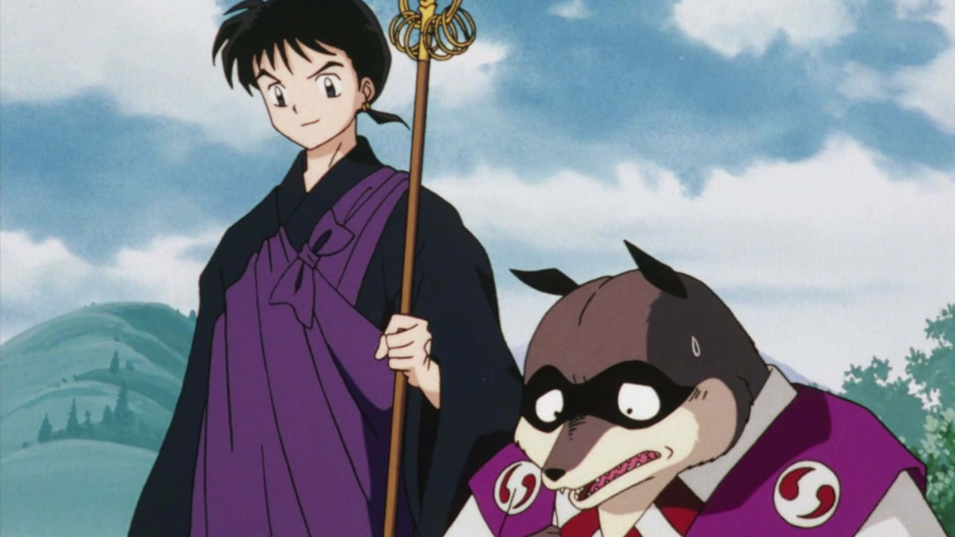 Miroku 桌布 壁紙 — 一位身穿紫色長袍的年輕動漫戰士，在雲霧繚繞的山景背景下，手持法杖，身旁站著一隻戴面具的狐狸精靈。