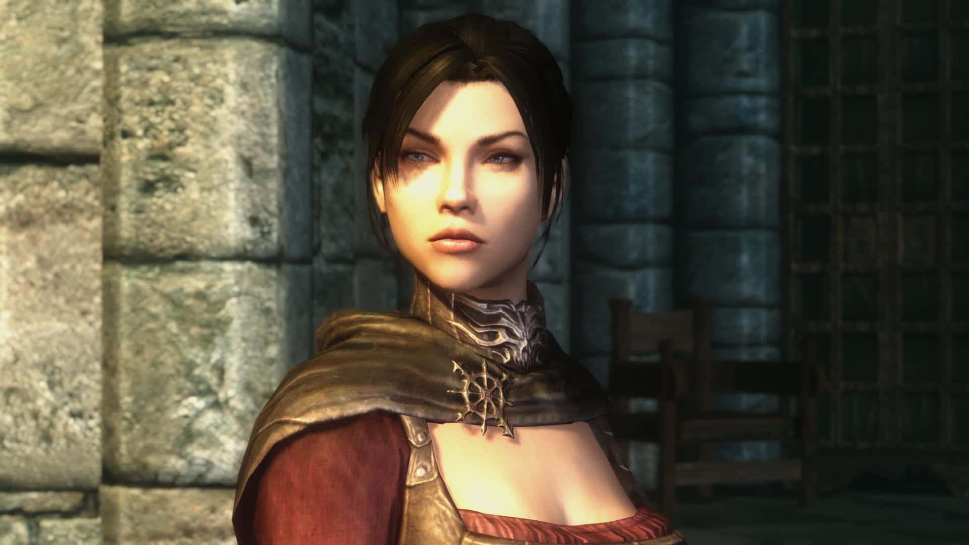 Skyrim Serana 桌布 壁紙 — 一位身穿華麗盔甲的女戰士，在燈光昏暗的中世紀大廳中，莊嚴地站在古老的石牆前。