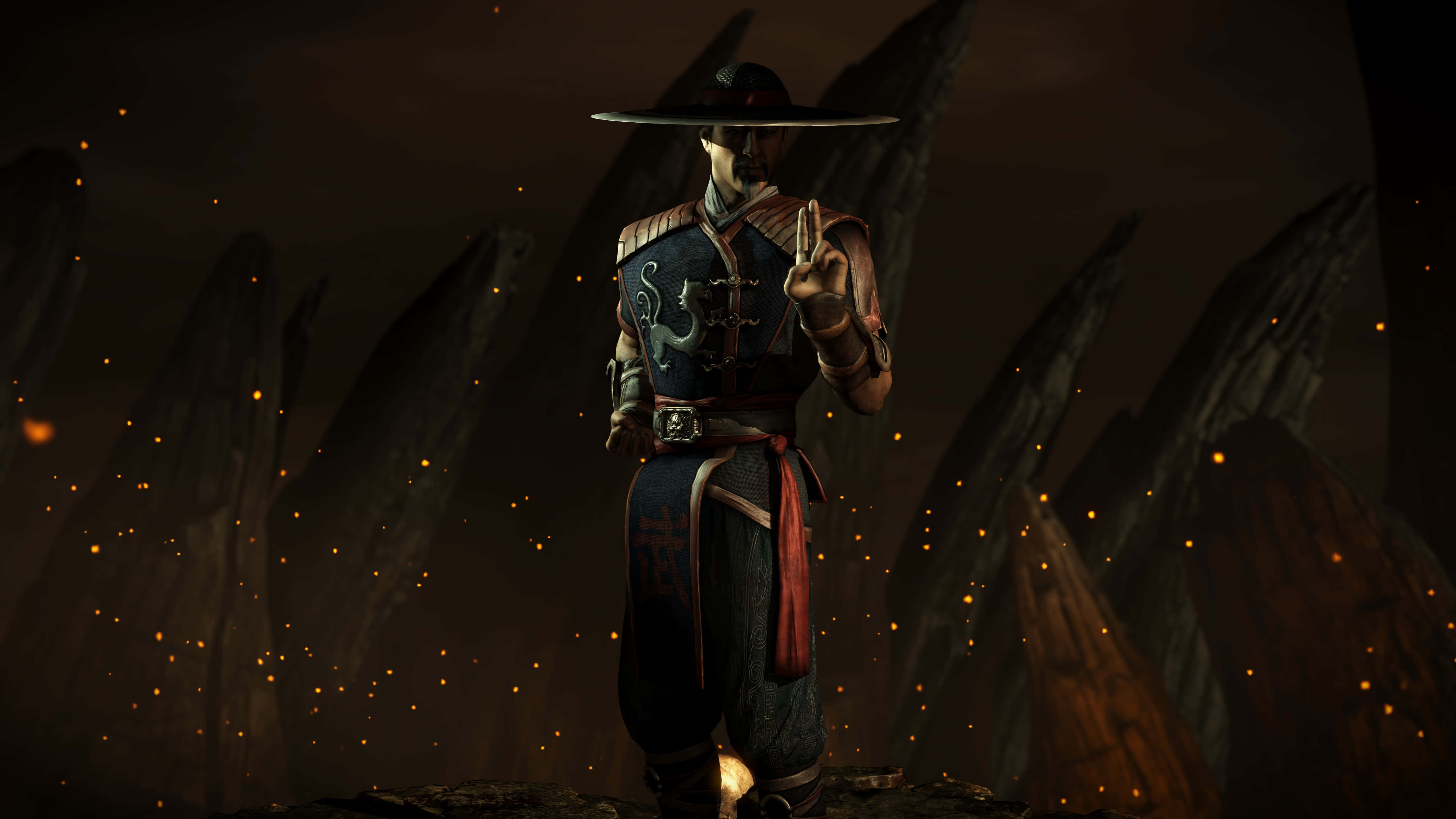 Mortal Kombat Kung Lao 桌布 壁紙 — 一位身穿華麗盔甲的武術家，在黑暗岩石背景下擺出姿勢，周圍漂浮著發光的餘燼。