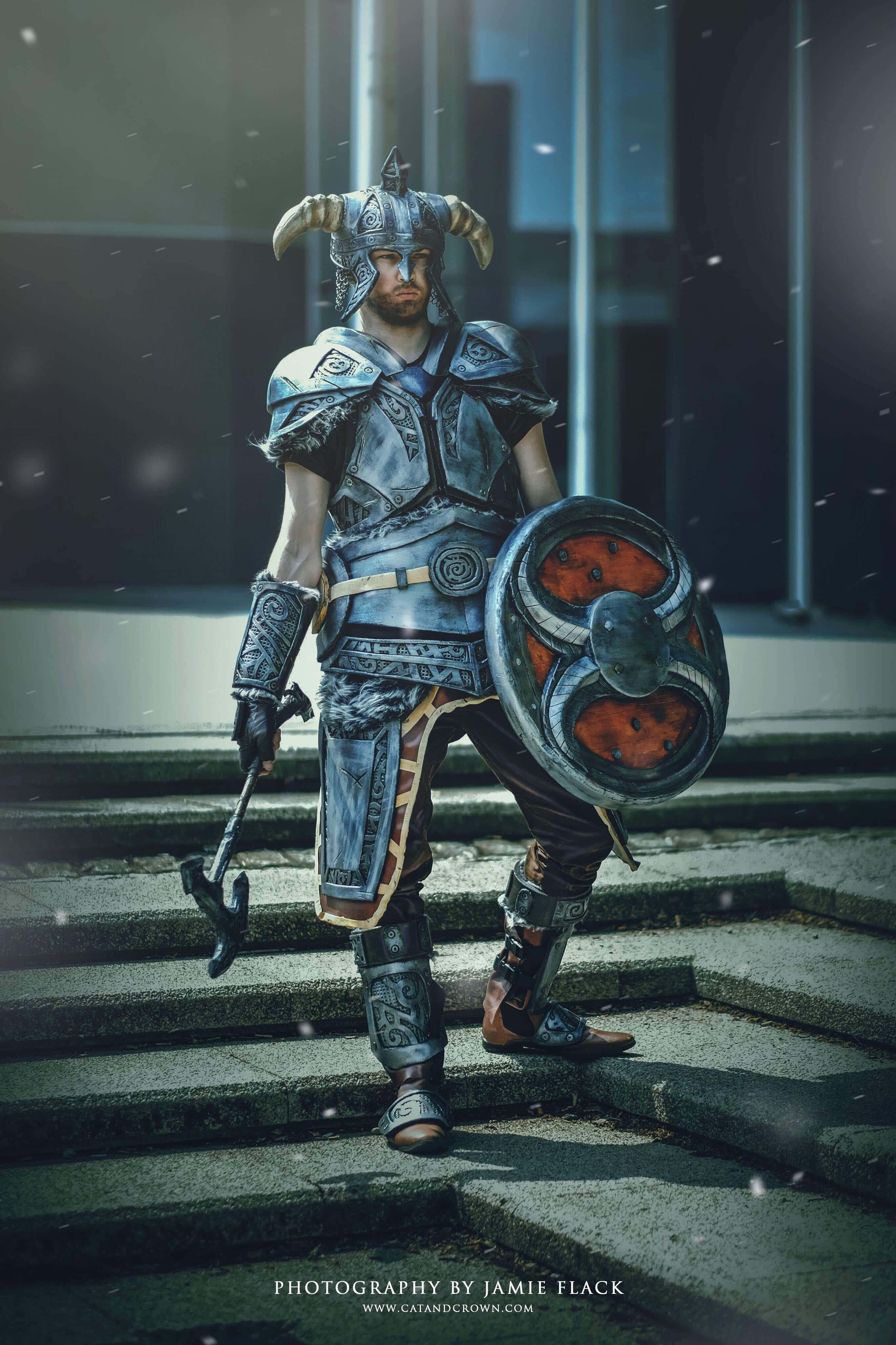 dovahkiin 桌布 壁紙 — 一位身穿華麗角盔和精細盔甲的戰士，站在石階上，手持盾牌和錘子，雪花飄落。