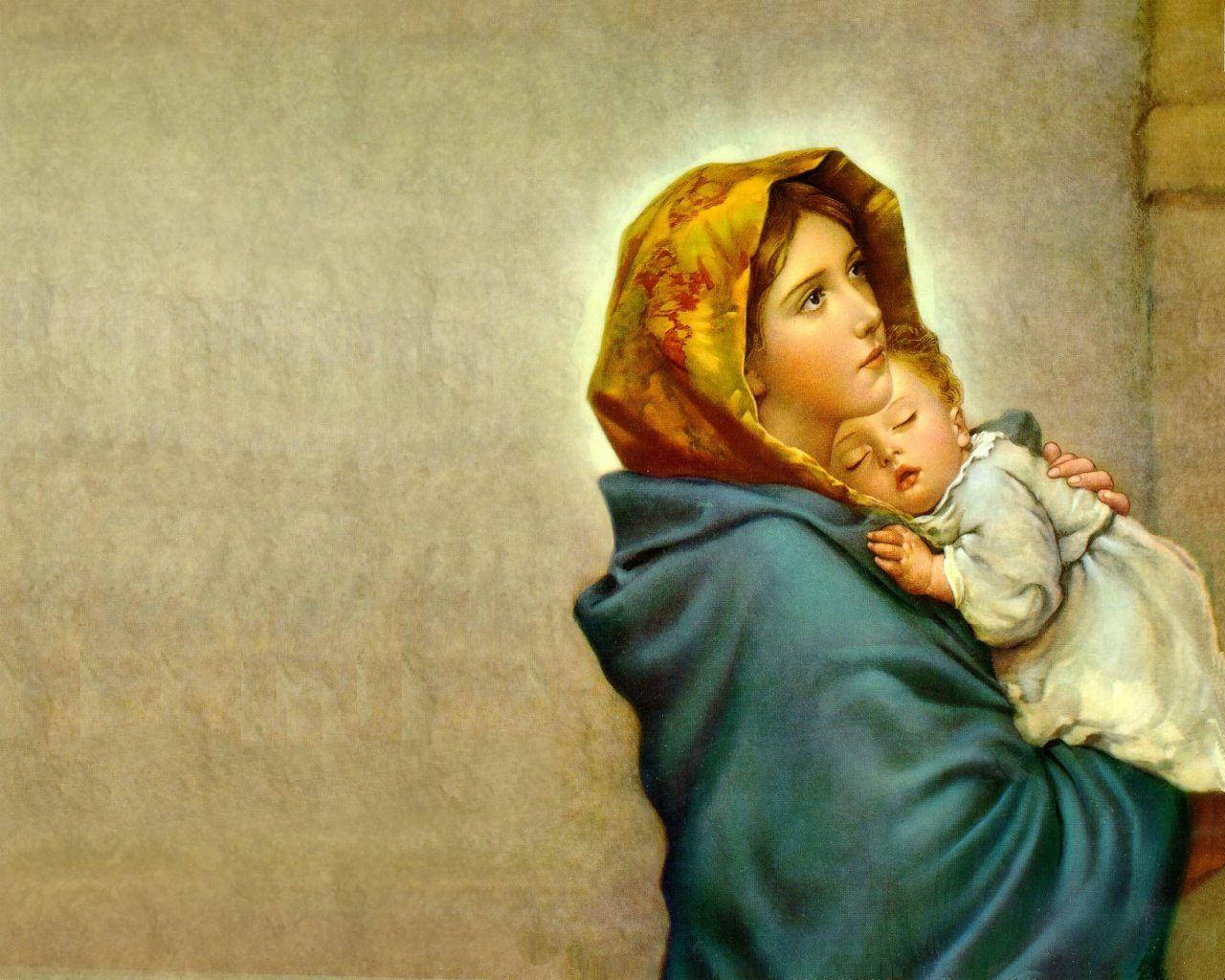 Mary 桌布 壁紙 — 一位身穿藍色長袍和黃色頭巾的寧靜母親，在柔和的石牆旁輕輕地抱著她熟睡的嬰兒。