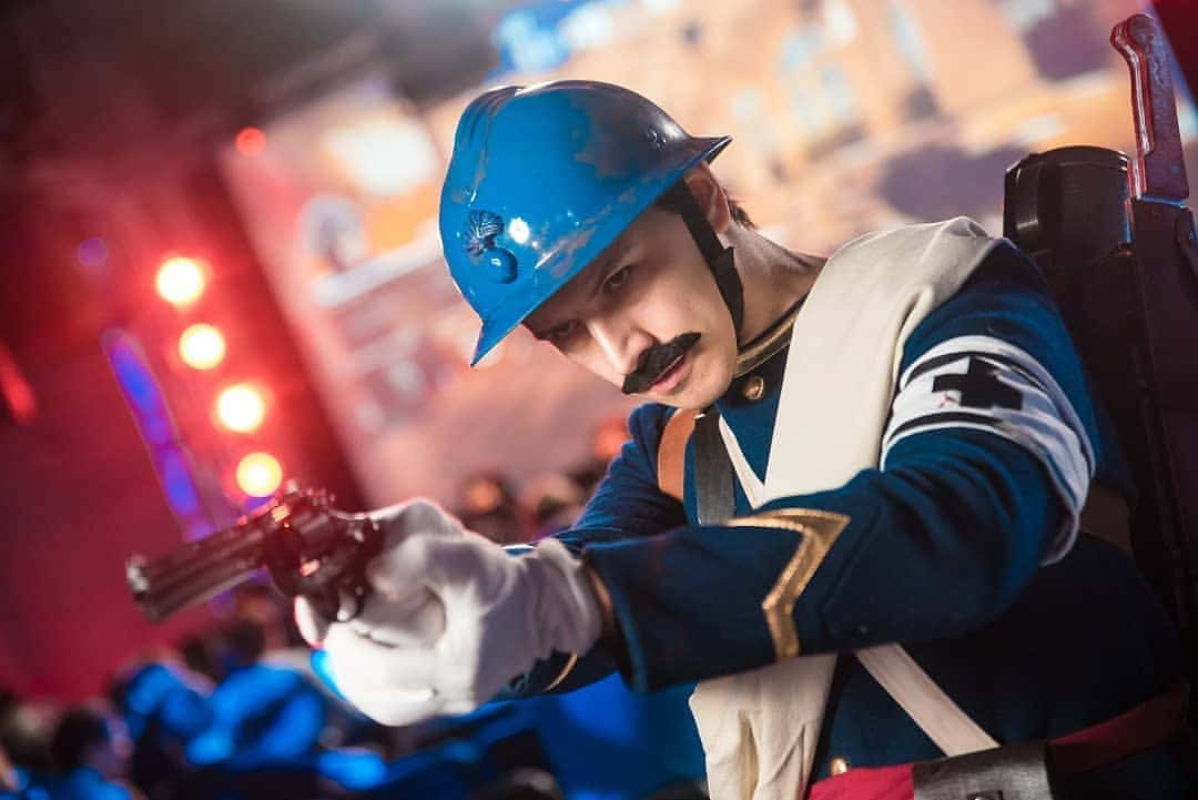 Rainbow Six Siege Doc 桌布 壁紙 — 一位身穿藍色頭盔和制服的Cosplayer在充滿活力的舞台燈光下，專注地瞄準左輪手槍。