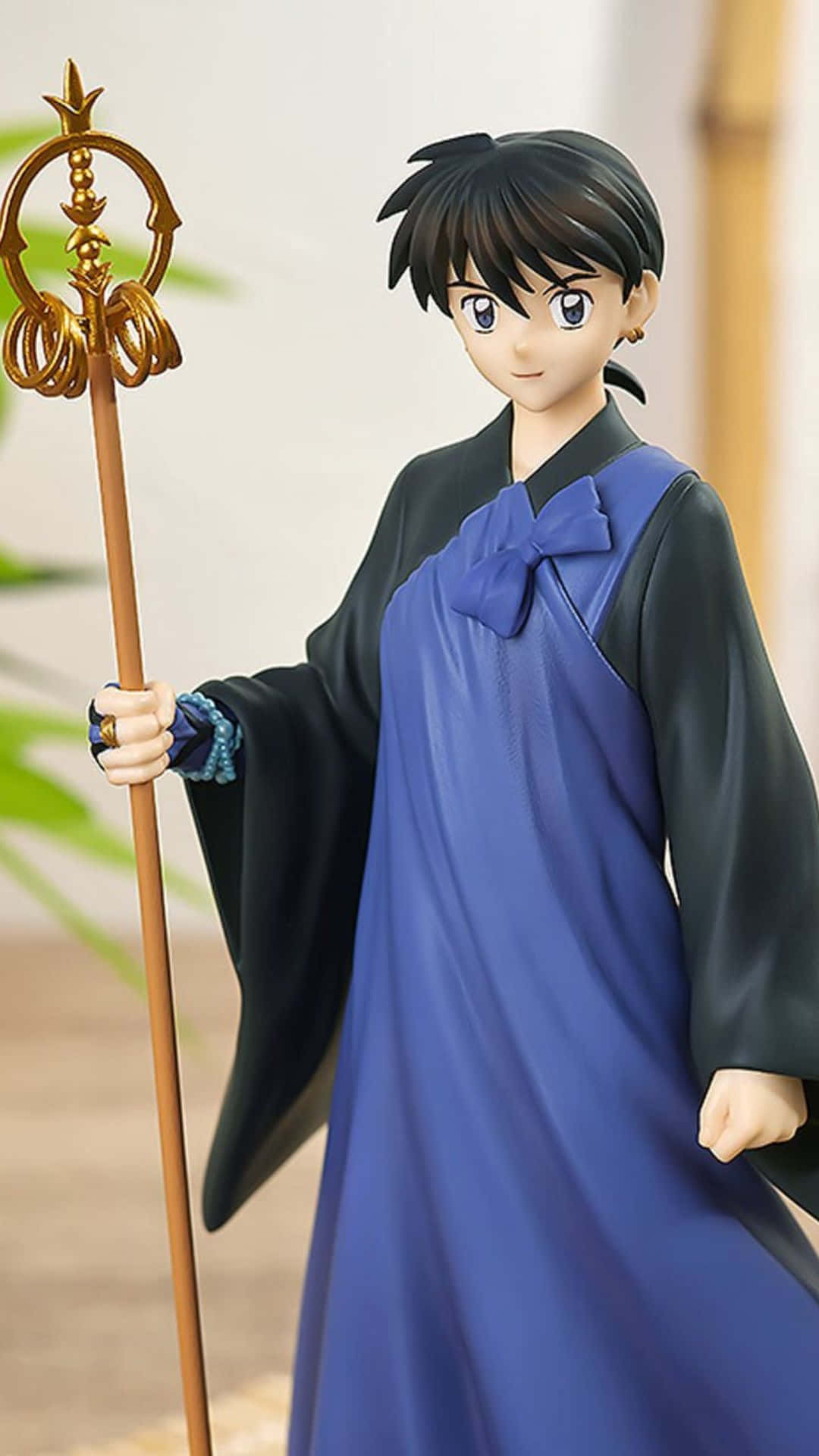 Miroku 桌布 壁紙 — 一位身穿藍黑長袍的年輕女性動漫人偶，手持頂部裝飾華麗的金色權杖。
