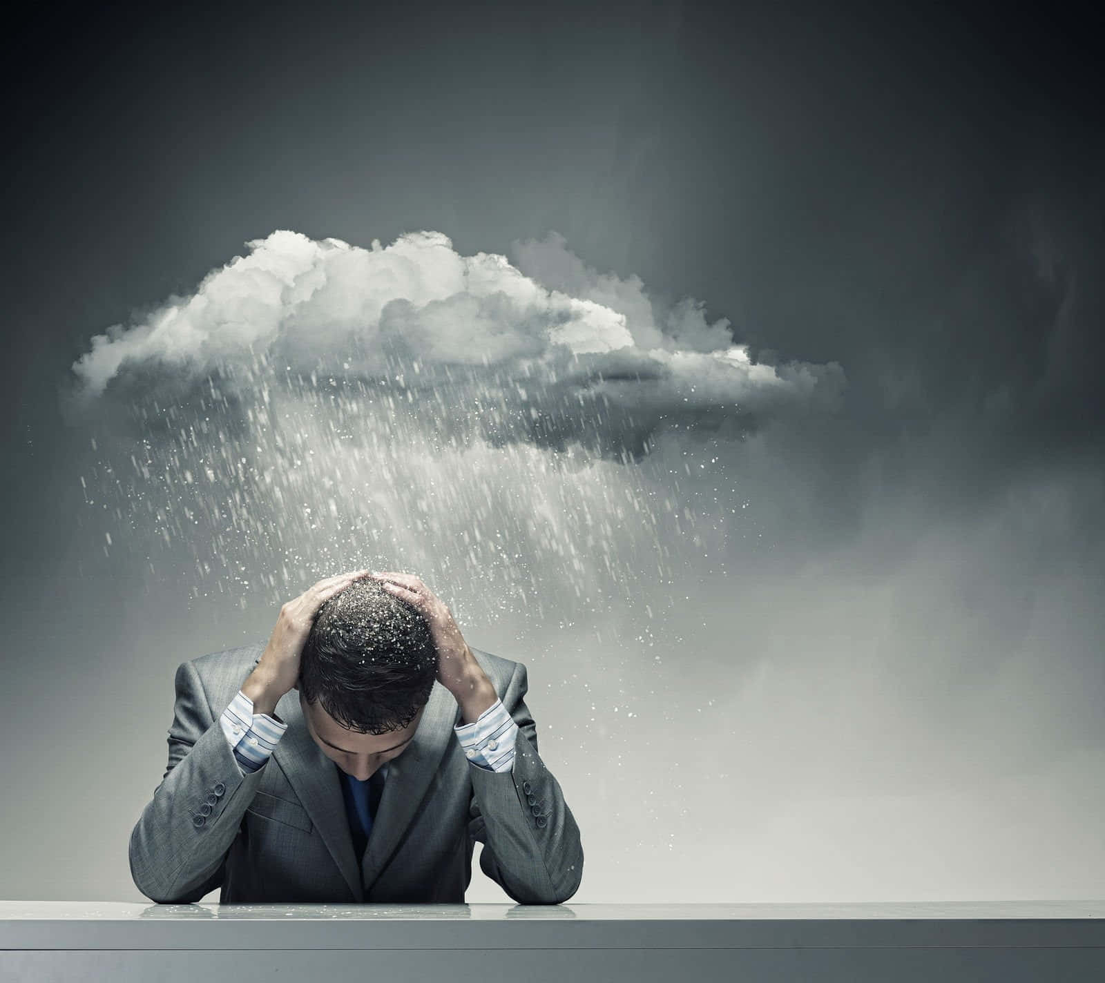 Dark Emotional 桌布 壁紙 — 一位身穿西裝的商人雙手抱頭，頭頂上有一片暴風雨雲直接向他降雨。