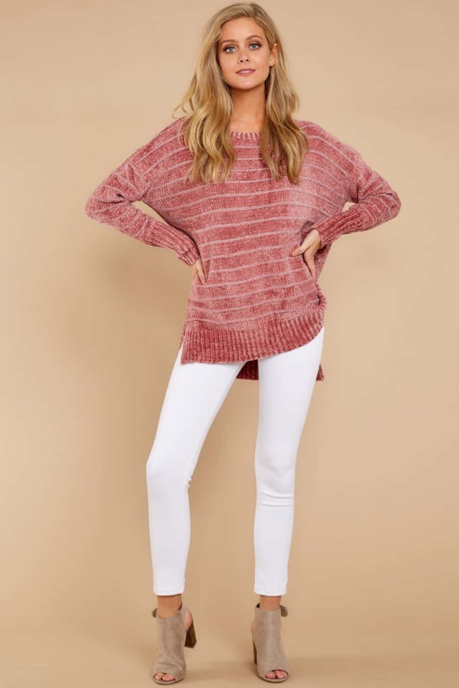 Pink Sweater 桌布 壁紙 — 一位身穿質感粉色毛衣和白色褲子的女性，在米色工作室背景前自信地擺姿勢。