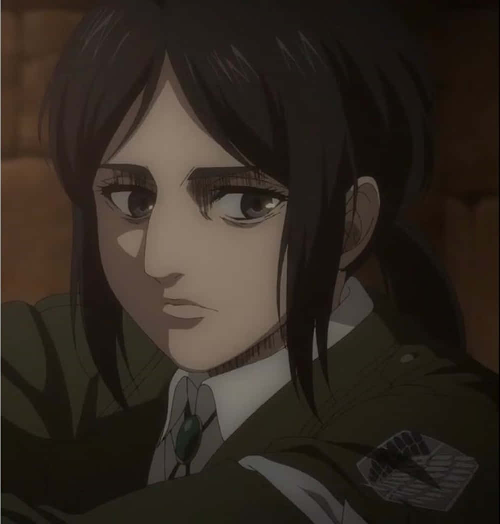 Pieck Finger 桌布 壁紙 — 一位身穿軍裝、繫著綠色領帶、佩戴徽章的堅定動漫女孩的特寫。