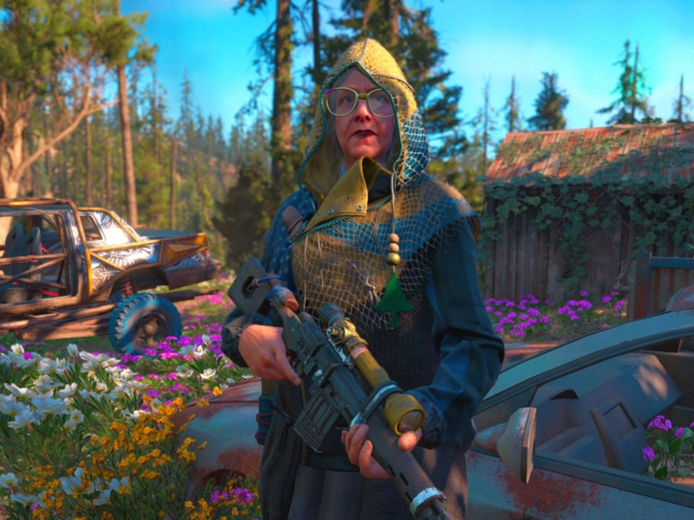 Far Cry New Dawn Nana 壁紙 — 一位身穿連帽服裝的老年女性，在陽光明媚的森林空地中，手持步槍，周圍是茂盛的花朵和廢棄的汽車。