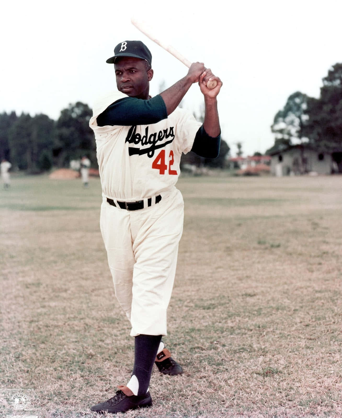 Jackie Robinson 桌布 壁紙 — 一位身穿道奇隊球衣、背號42的黑人棒球選手，在陰天下的草地上準備打擊。
