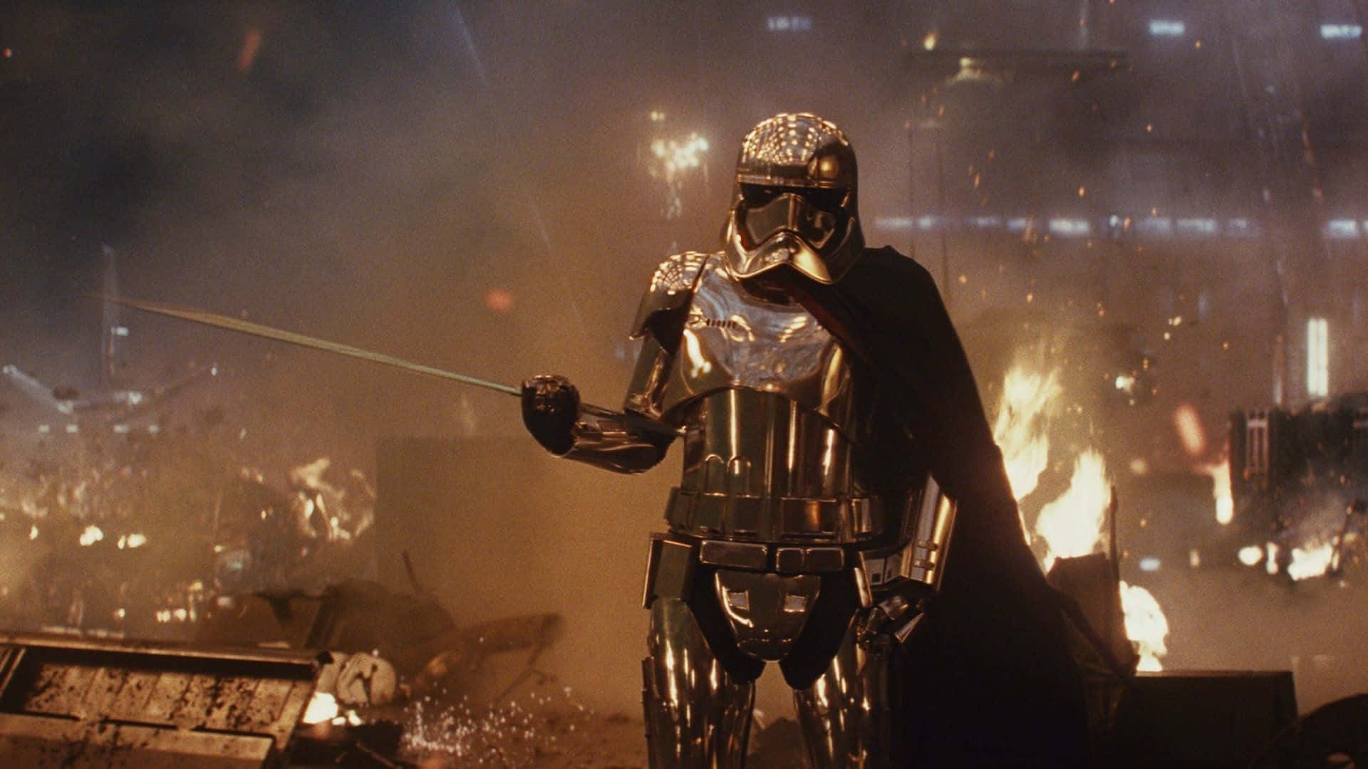 Captain Phasma 桌布 壁紙 — 一位身穿金色盔甲、披著斗篷的戰士站在燃燒的廢墟城市中，手持發光的劍。