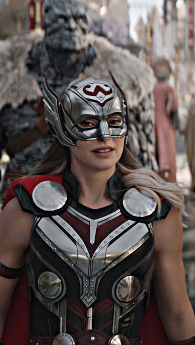 Jane Foster 桌布 壁紙 — 一位身穿銀色和紅色盔甲的女性雷神自信地站立，身後有一個大型裝甲人物，背景為奇幻設定。
