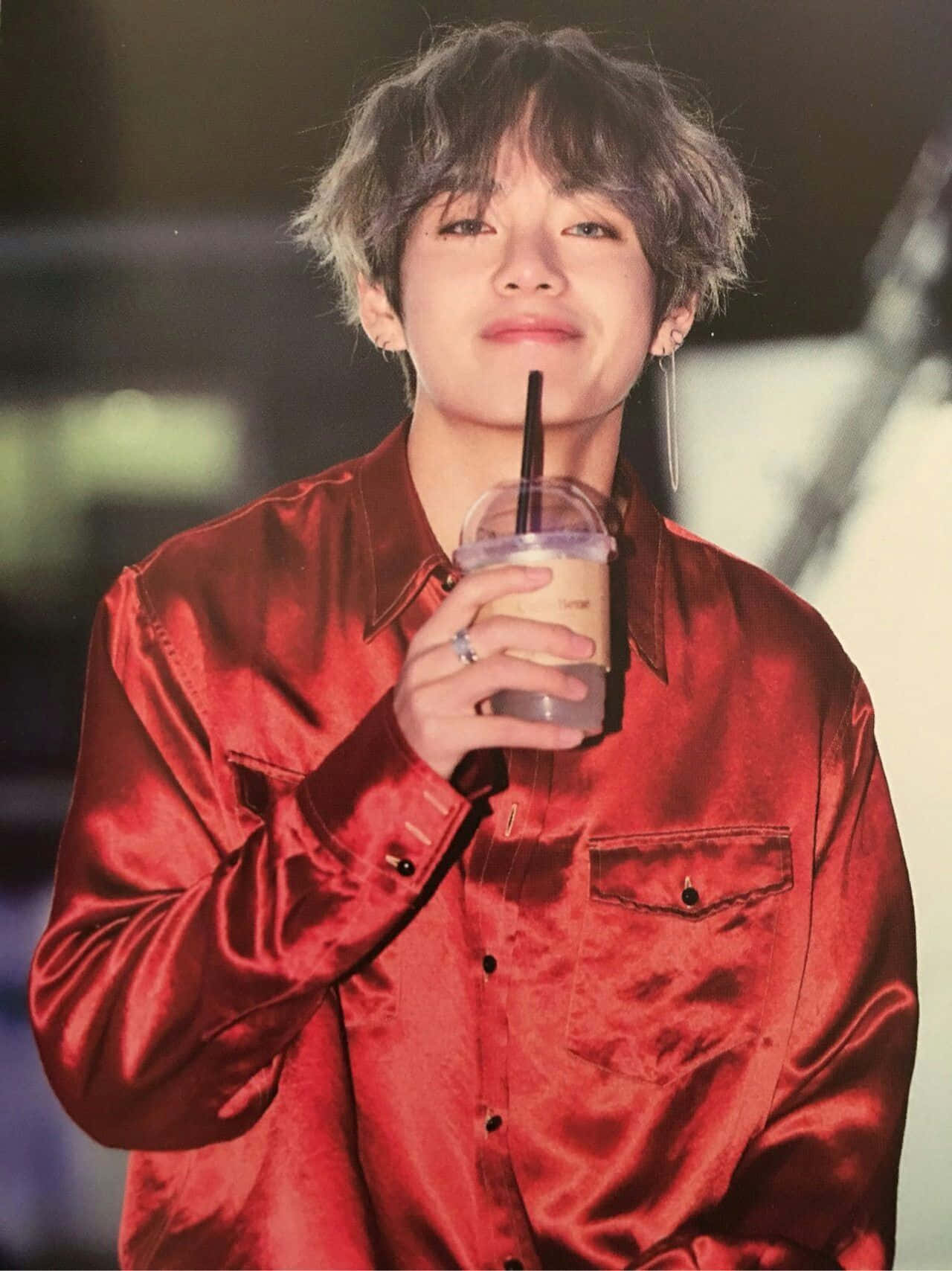 Taehyung Cute 桌布 壁紙 — 一位身穿閃亮紅衫的年輕男子微笑著，手持一杯附有吸管的飲料。