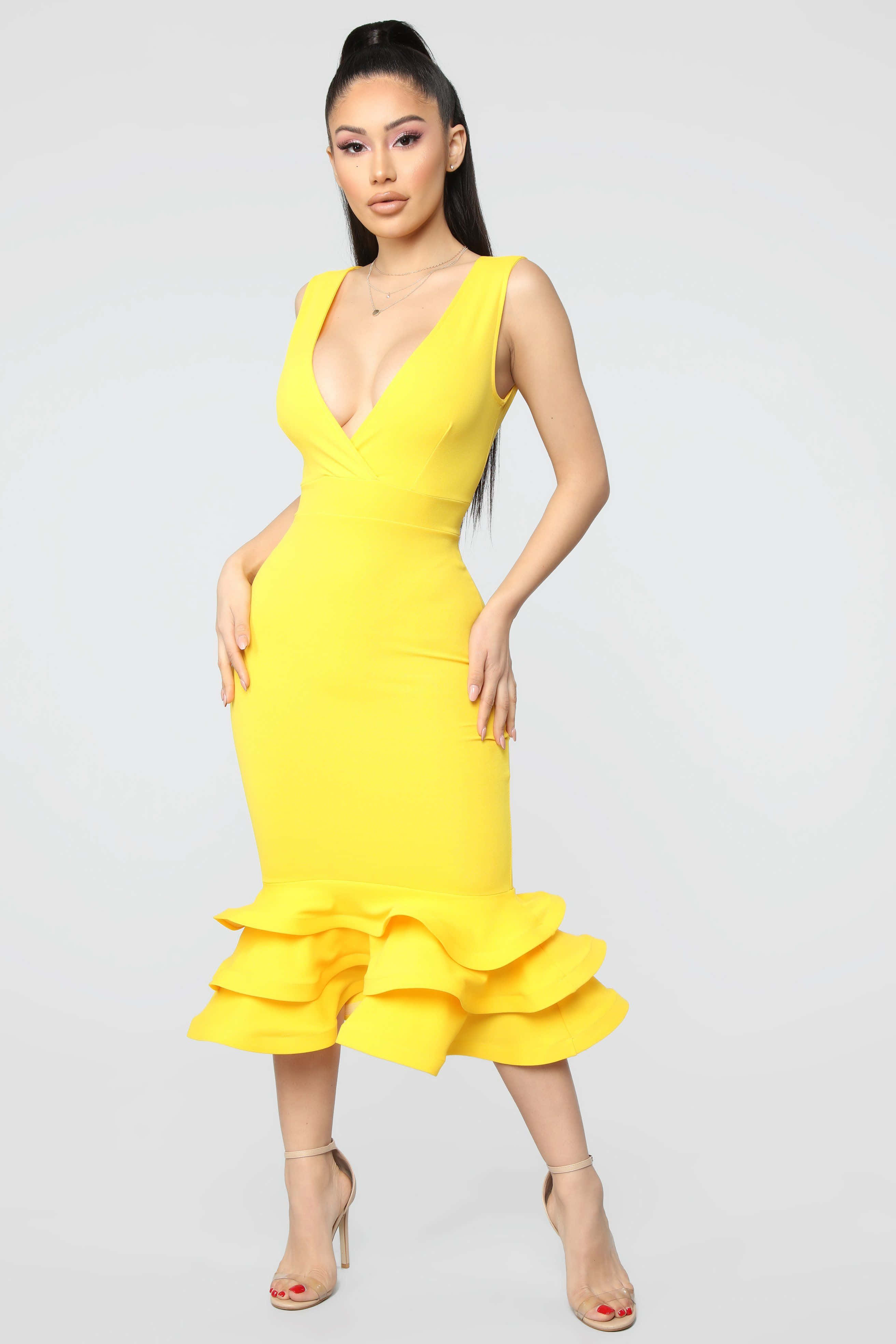 Yellow Fashion 桌布 壁紙 — 一位身穿鮮黃色荷葉邊中長裙的女性在純白背景前自信地擺姿勢。