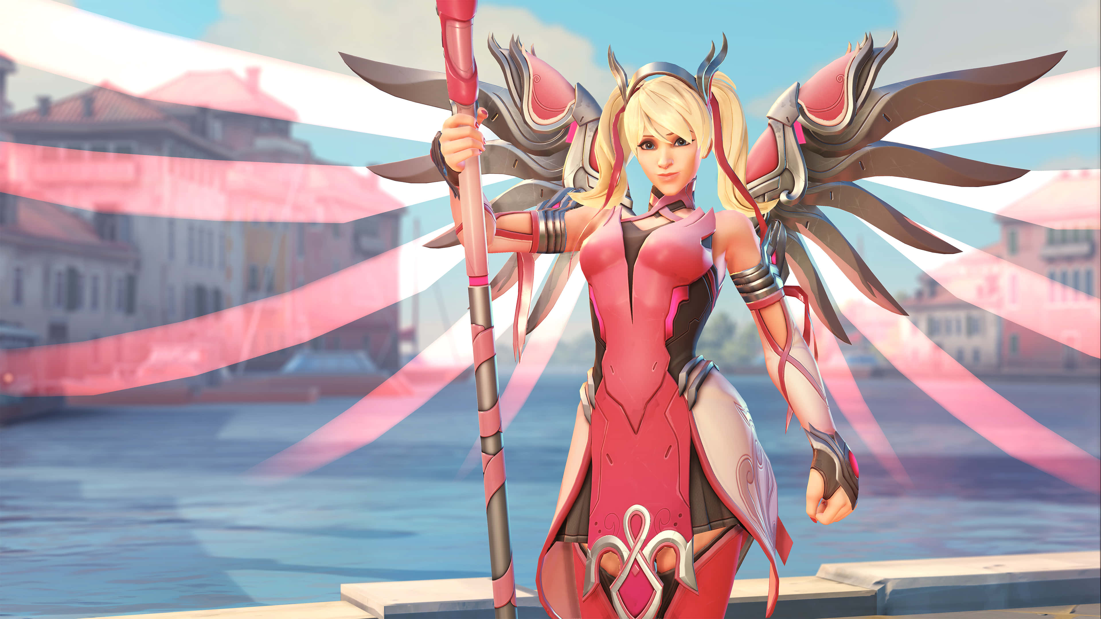 Overwatch Mercy 桌布 壁紙 — 一位金髮動漫戰士身穿粉紅色盔甲，手持法杖和帶翼護手，自信地站在模糊的威尼斯運河背景前。