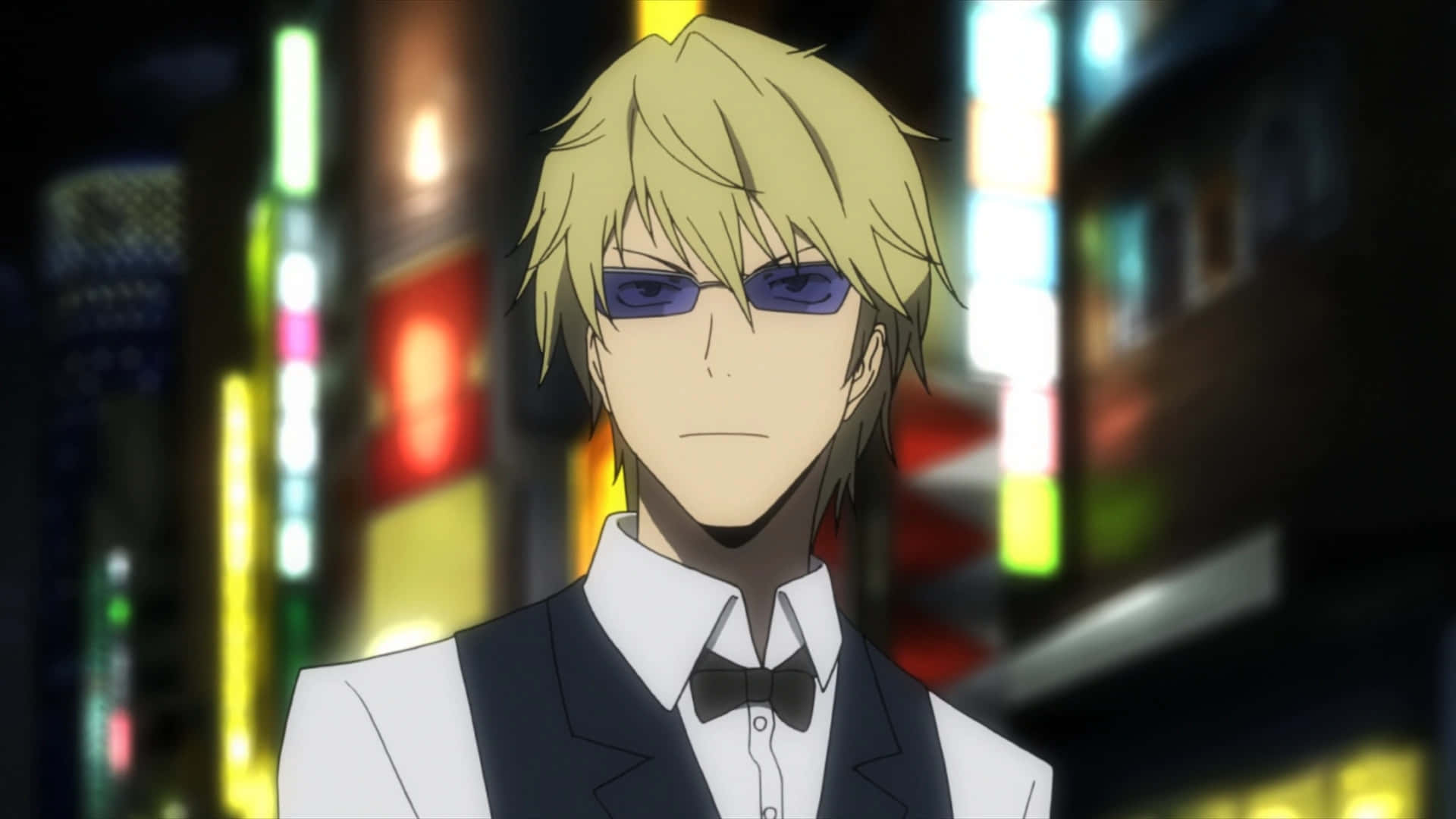 Shizuo Heiwajima 桌布 壁紙 — 一位金髮動漫男子身穿燕尾服和太陽眼鏡，站在霓虹燈閃爍的城市夜景中，身後有模糊的發光招牌。
