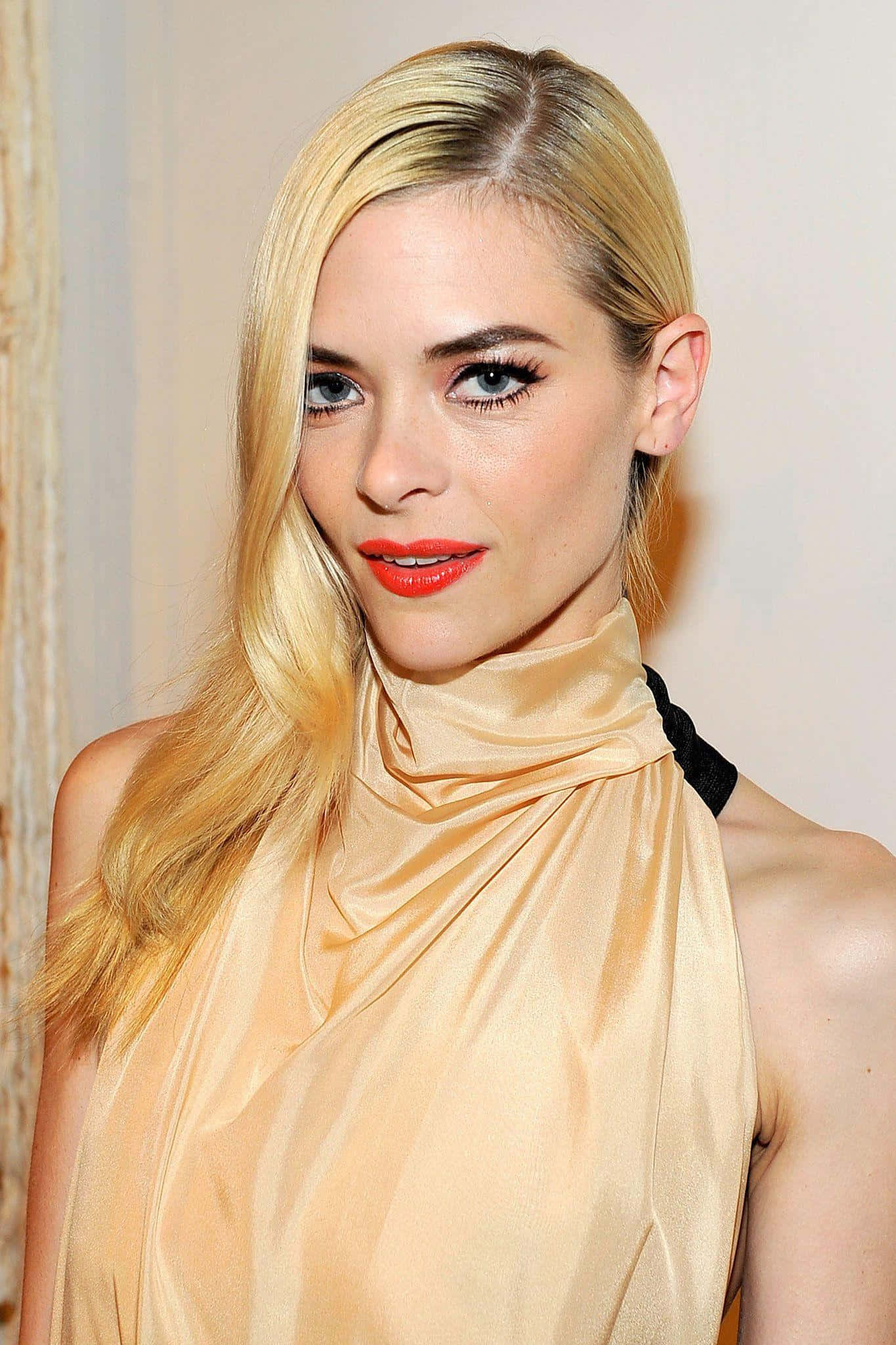 Jaime King 桌布 壁紙 — 一位金髮女性嘅特寫肖像，佢有鮮紅色嘴唇同優雅嘅金色緞面服裝，背景係柔和嘅中性色調。