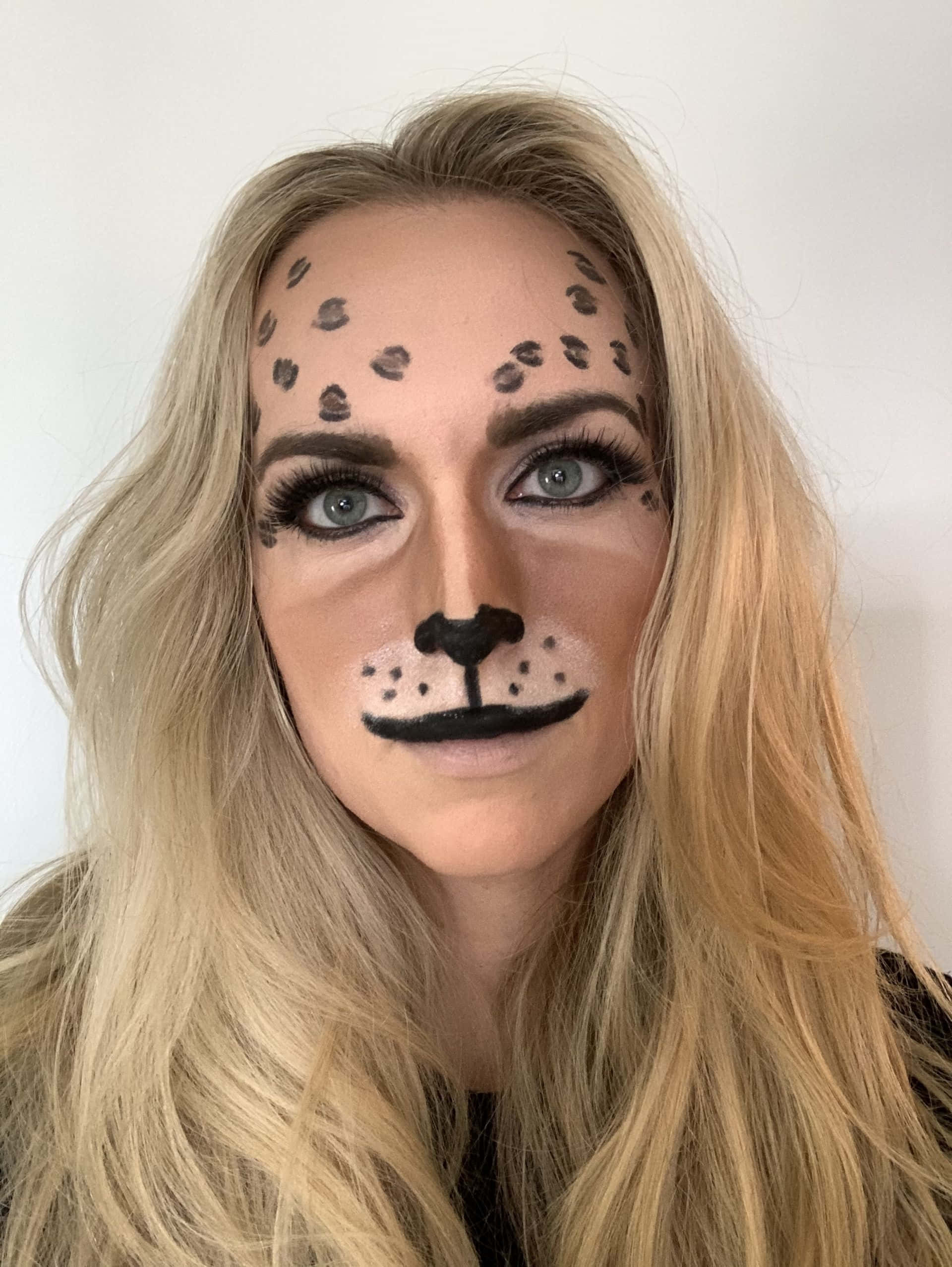 Halloween Makeup 桌布 壁紙 — 一位金髮女性在純白背景上繪有詳細的豹紋臉部彩繪，包括斑點和鼻子。