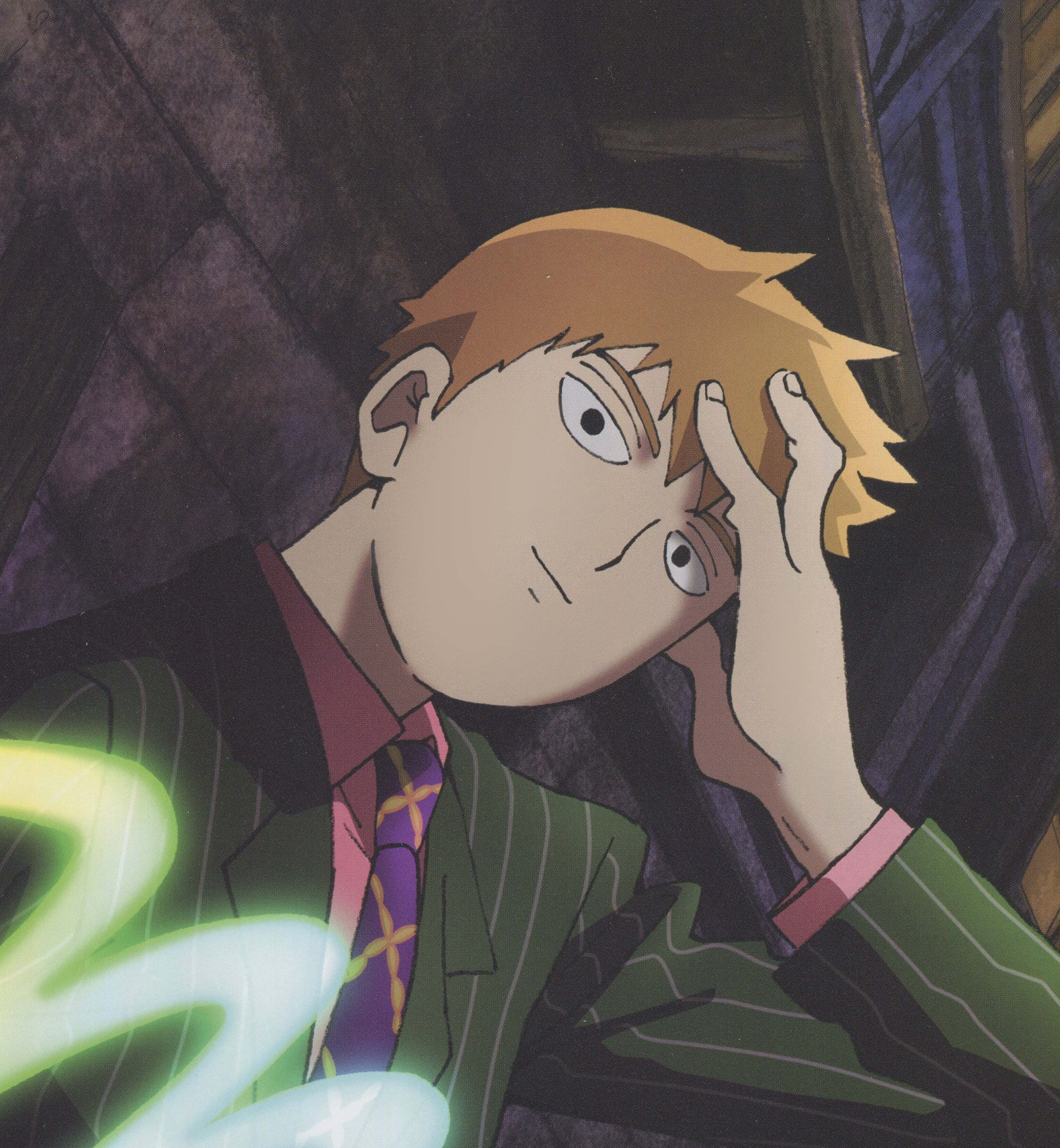 Arataka Reigen 桌布 壁紙 — 一位金髮年輕動漫男子身穿綠色西裝，在黑暗石牆旁因發光的綠色能量而痛苦地抱著頭。