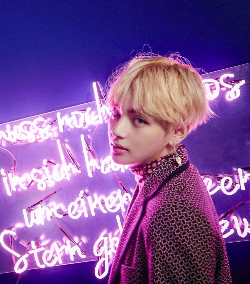 Taehyung Cute 桌布 壁紙 — 一位金髮年輕男子站在發光的紫色霓虹燈牌前，燈牌上有德文文字，燈光效果戲劇化。