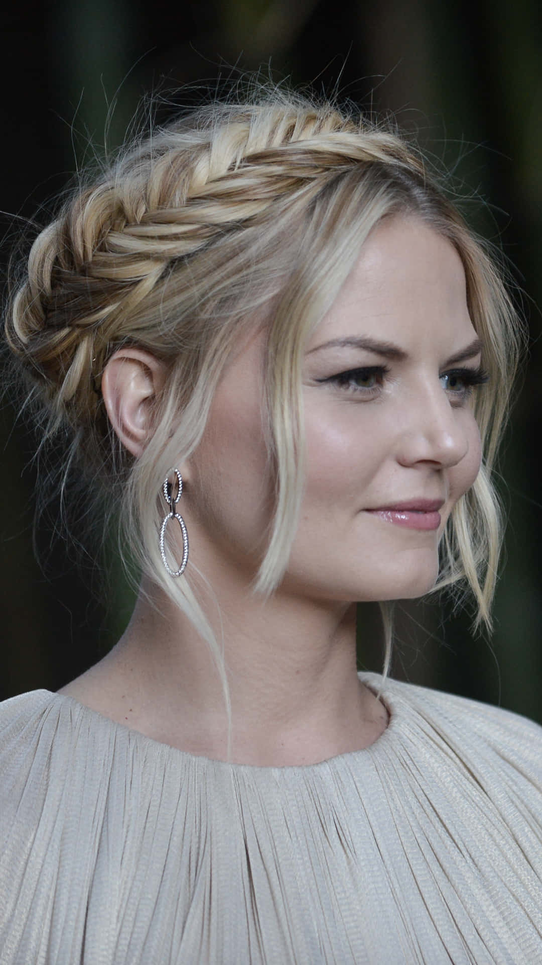 jennifer morrison 桌布 壁紙 — 一位金髮辮子和銀耳環的女性，在模糊的綠色背景下側面沉思地凝視。