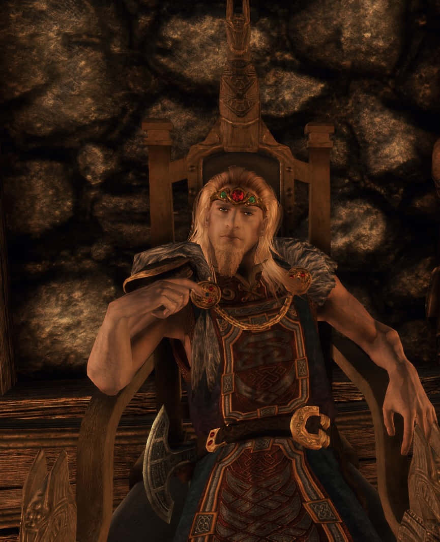 Jarl Balgruuf 桌布 壁紙 — 一位金髮鬍鬚的威嚴戰士坐在昏暗石室中的華麗王座上，身穿精緻盔甲和鑲寶石頭帶。