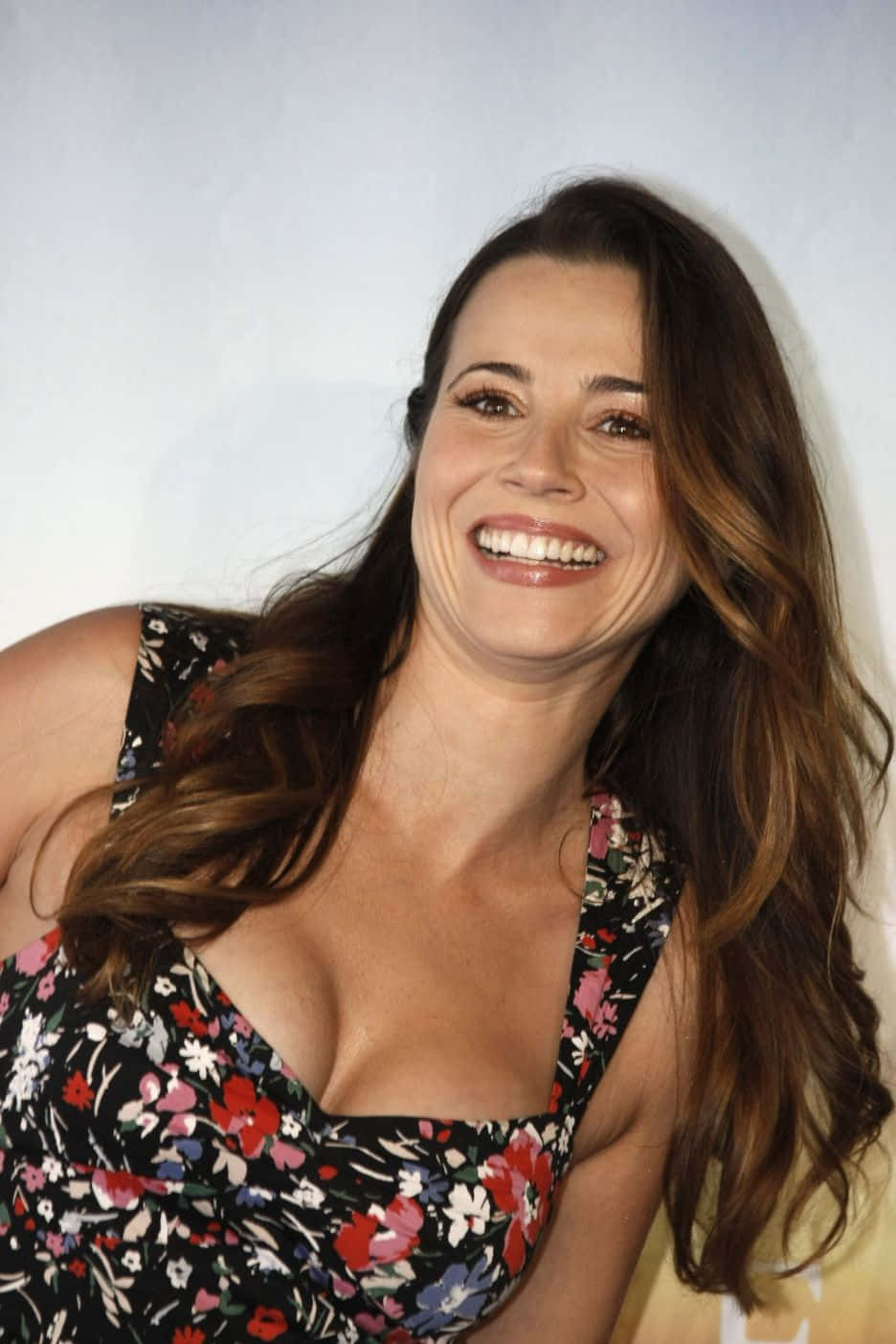 linda cardellini 桌布 壁紙 — 一位長棕髮的女性在純白背景下穿著碎花裙燦爛微笑。