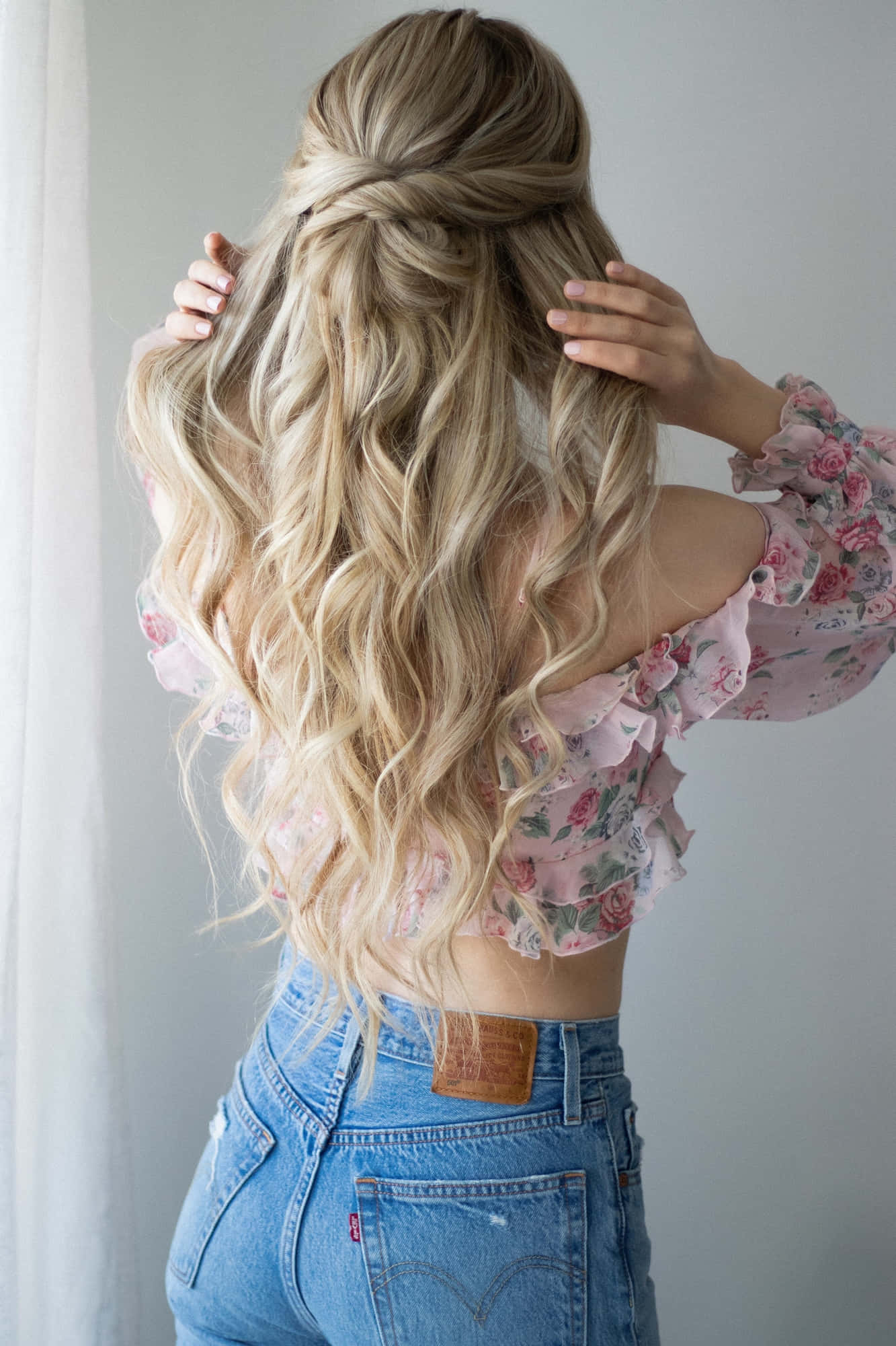 hair 桌布 壁紙 — 一位長波浪金髮半紮辮子的女性，穿著花卉上衣和牛仔褲，從背後看。