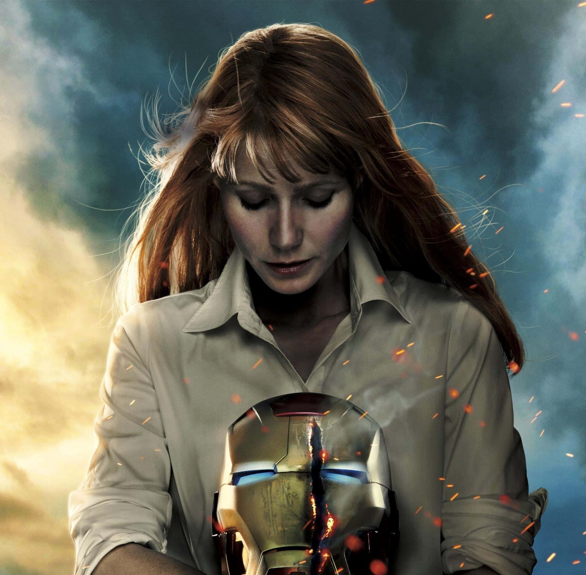 Pepper Potts 桌布 壁紙 — 一位長紅髮的女性手持破裂的鋼鐵人頭盔，火花在暴風雨的天空中飛舞。