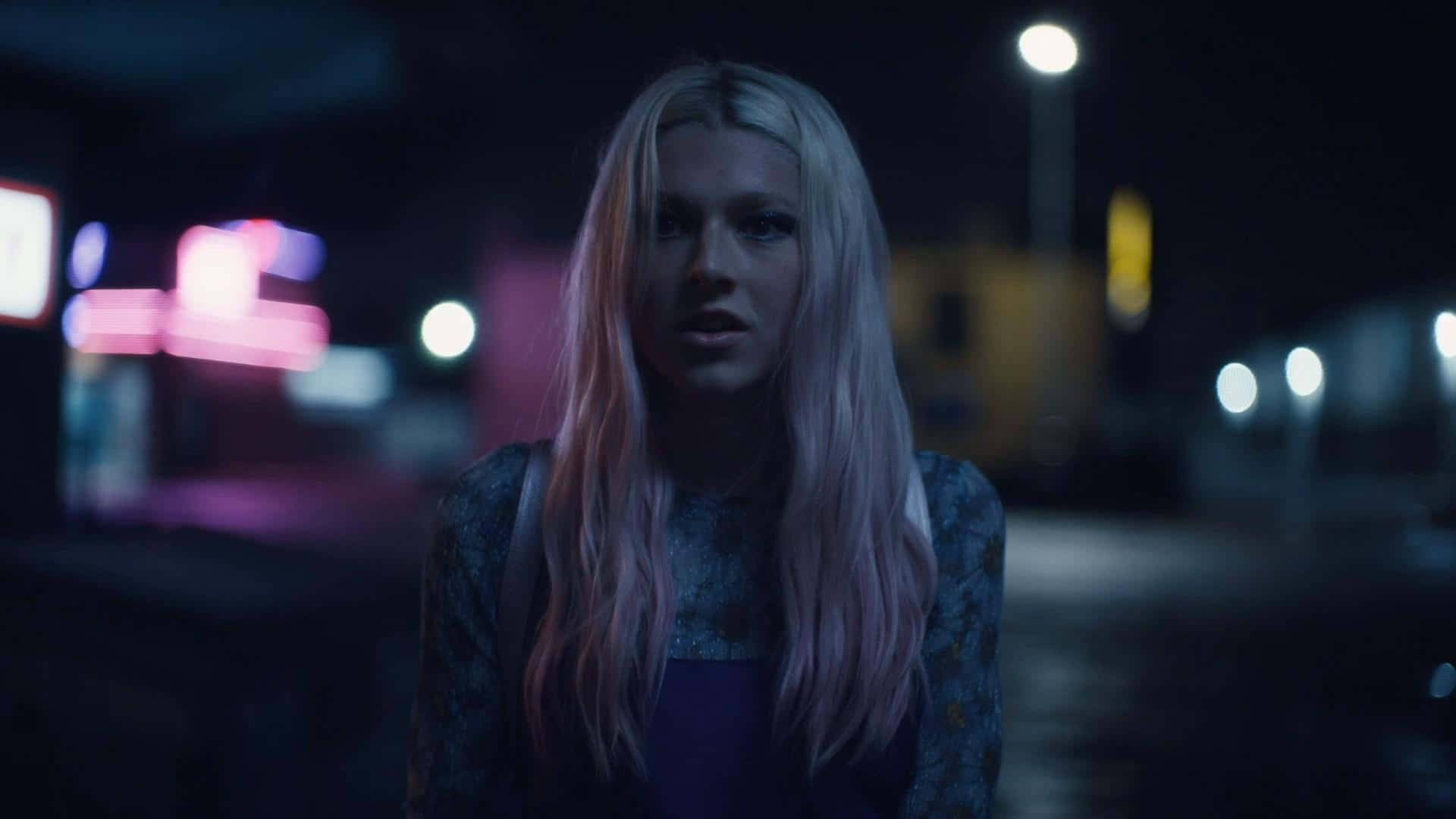 euphoria 桌布 壁紙 — 一位長金髮的年輕女性夜晚站在昏暗的城市街道上，被霓虹燈和路燈照亮。