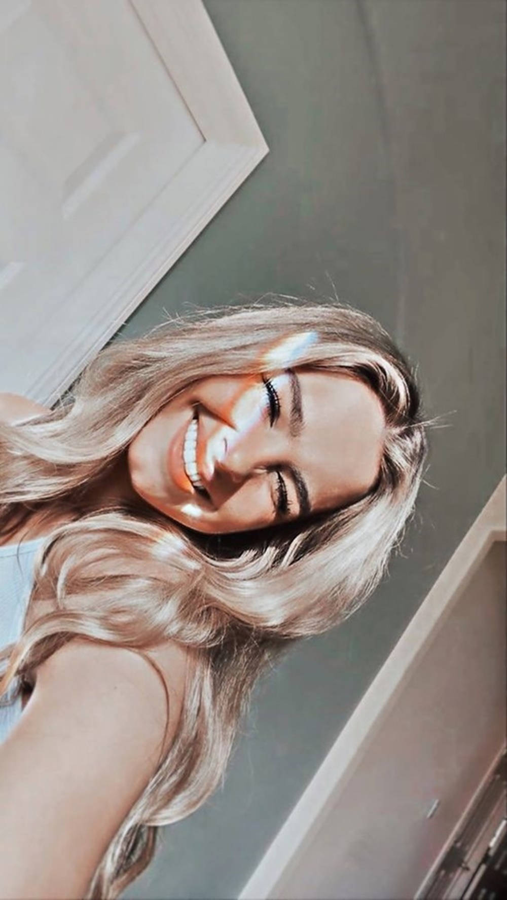 Smile 桌布 壁紙 — 一位長金髮的快樂女性在柔和光線的室內環境中開懷大笑。