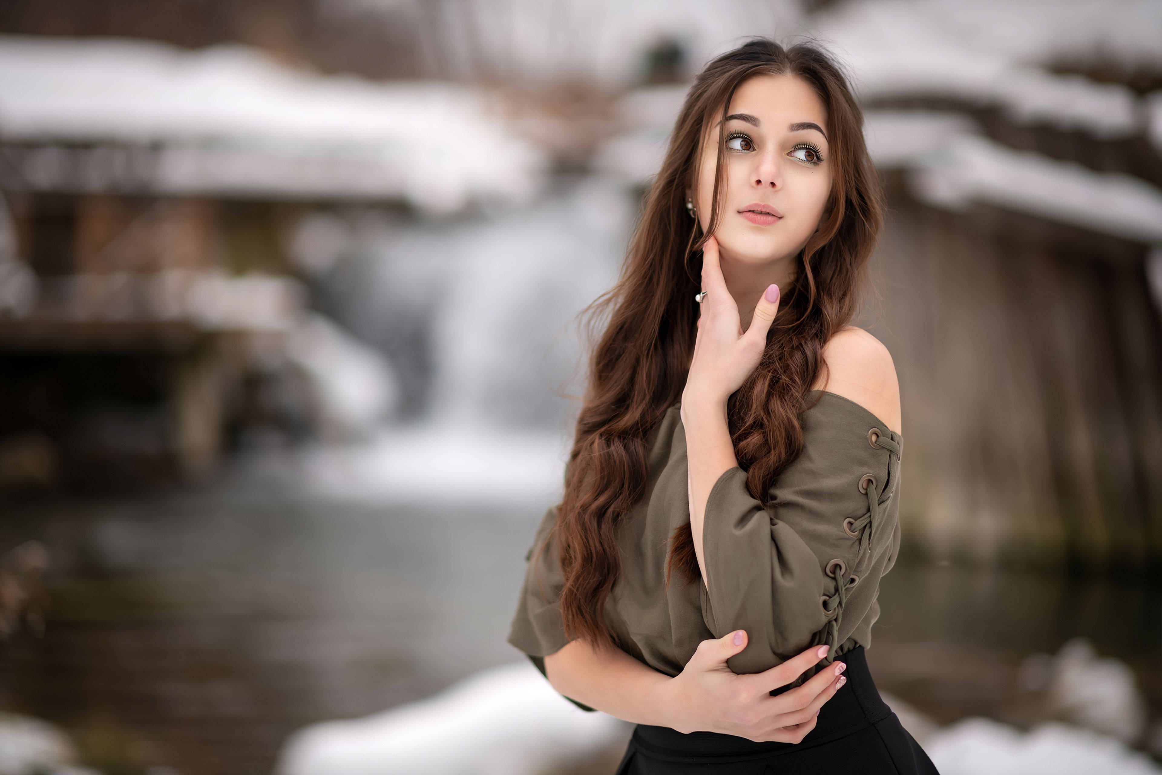 Woman 桌布 壁紙 — 一位長長棕色頭髮的年輕女子站在被雪覆蓋的瀑布旁，抬頭仰望，表情若有所思。