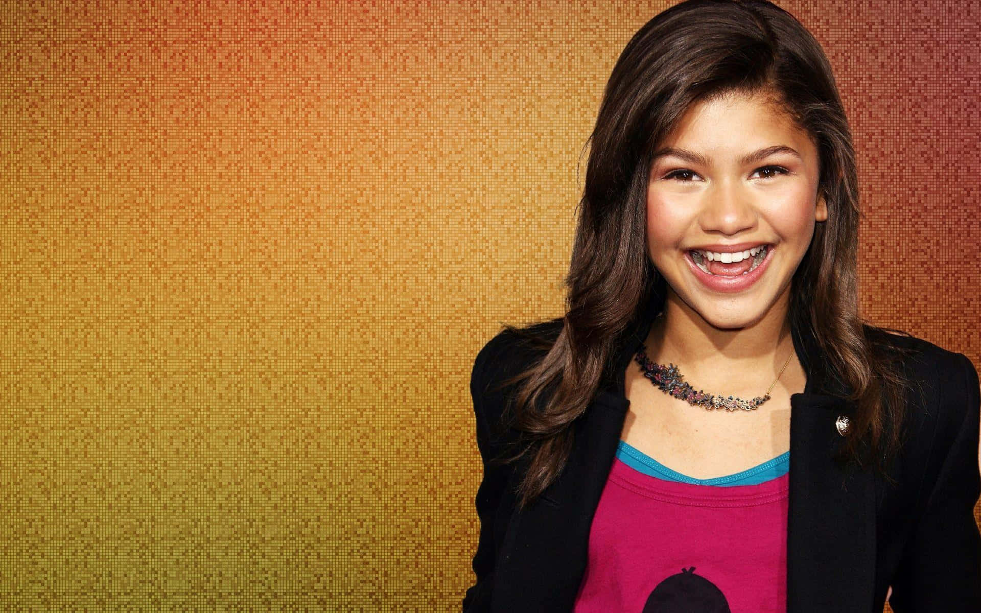 Zendaya 桌布 壁紙 — 一位長髮棕色的年輕女子在溫暖的漸變像素背景前燦爛微笑。