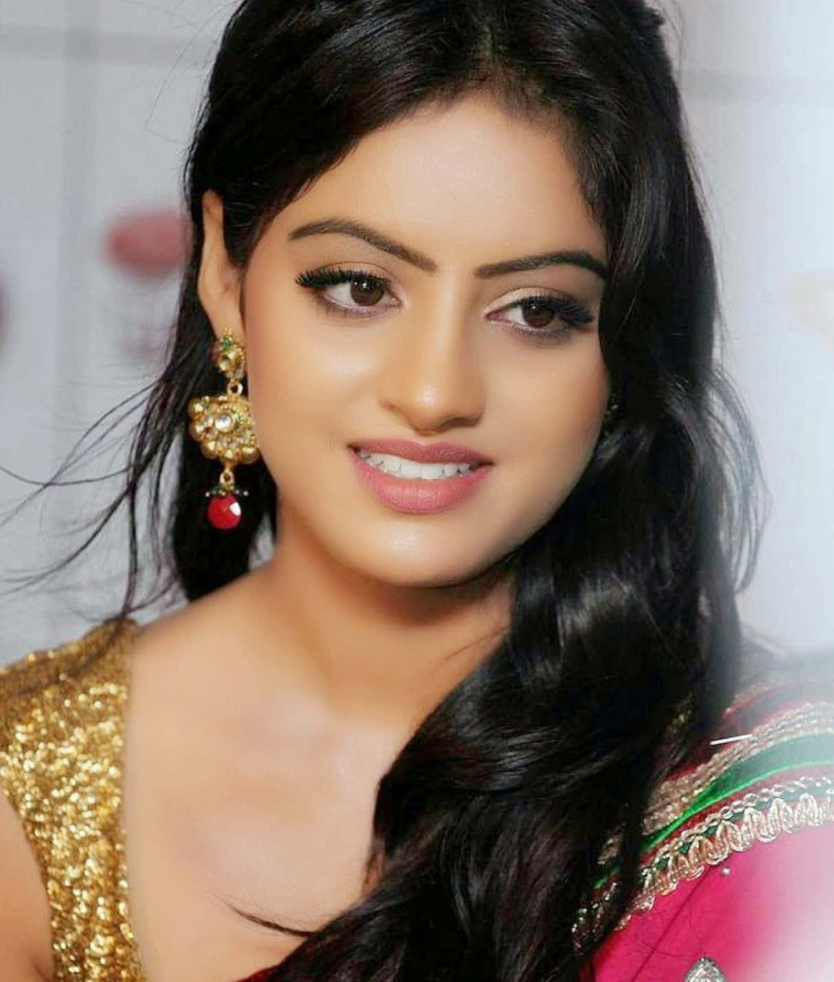 Indian Girl 桌布 壁紙 — 一位長黑髮女性的特寫肖像，身穿金色亮片服飾和華麗耳環。