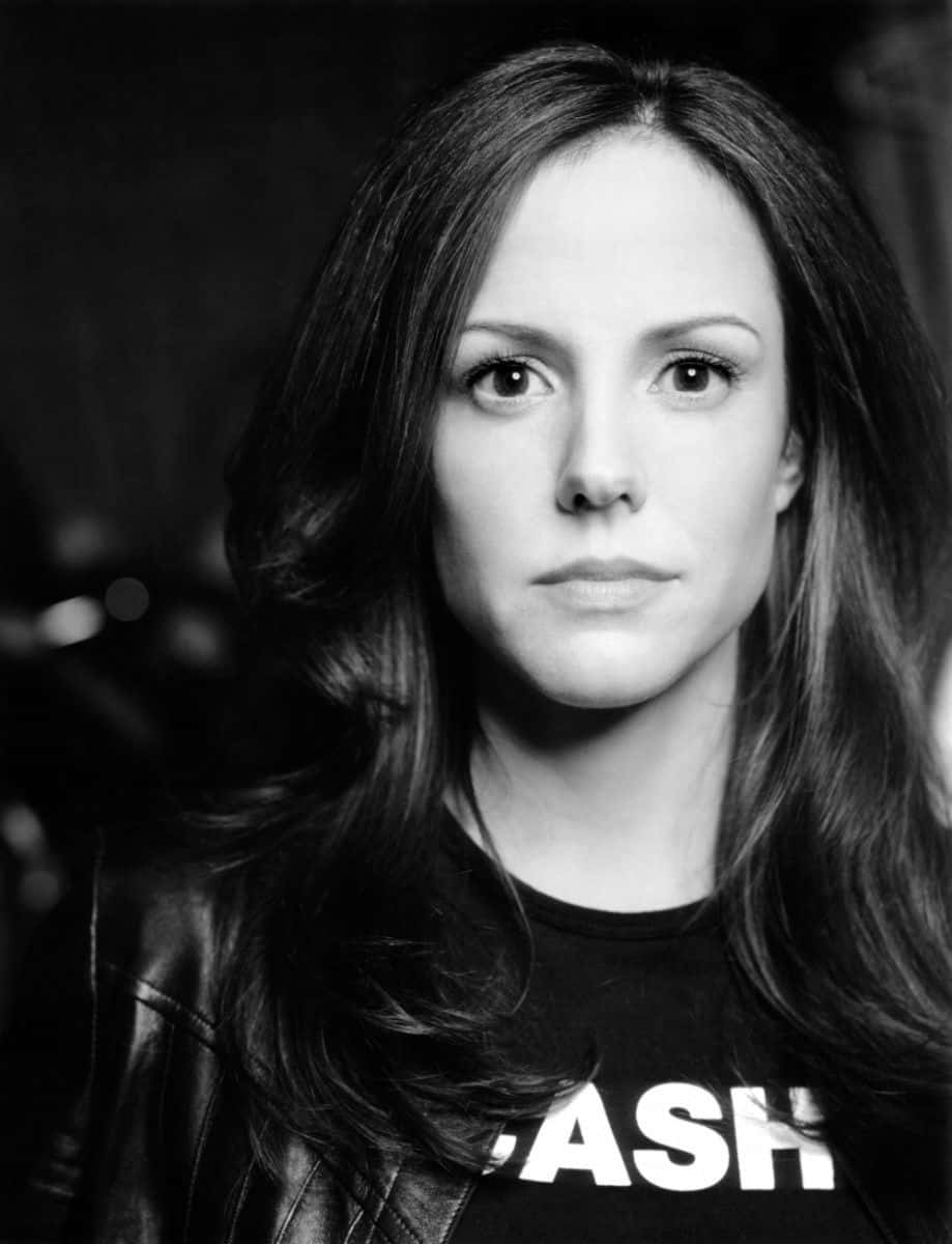 mary louise parker 桌布 壁紙 — 一位長黑髮女性穿著皮夾克和一件印有 'CASH' 字樣的T恤的黑白肖像。