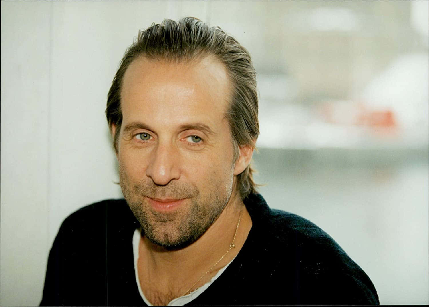 Peter Stormare 桌布 壁紙 — 一位頭髮花白、留鬍鬚的男士，穿著黑色毛衣，背景模糊的 close-up 肖像。