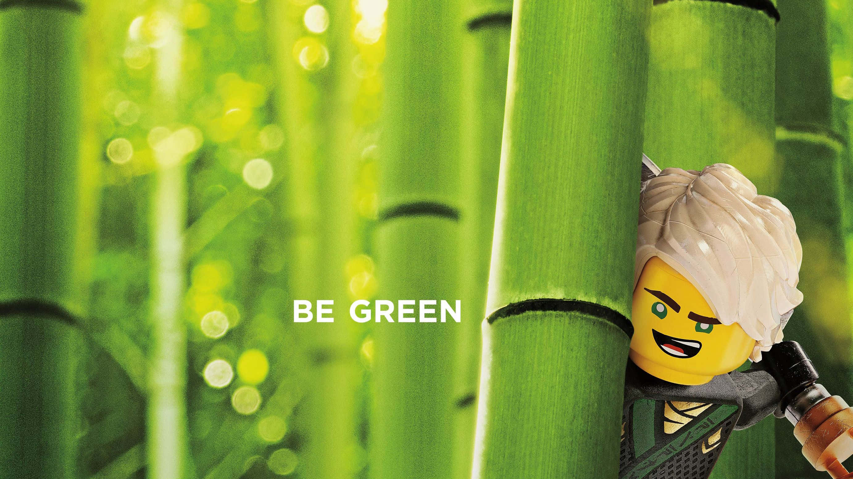 Ninjago 桌布 壁紙 — 一個 LEGO Ninjago 角色從充滿活力的綠色竹莖後面窺視，背景中「BE GREEN」文字柔和地發光。