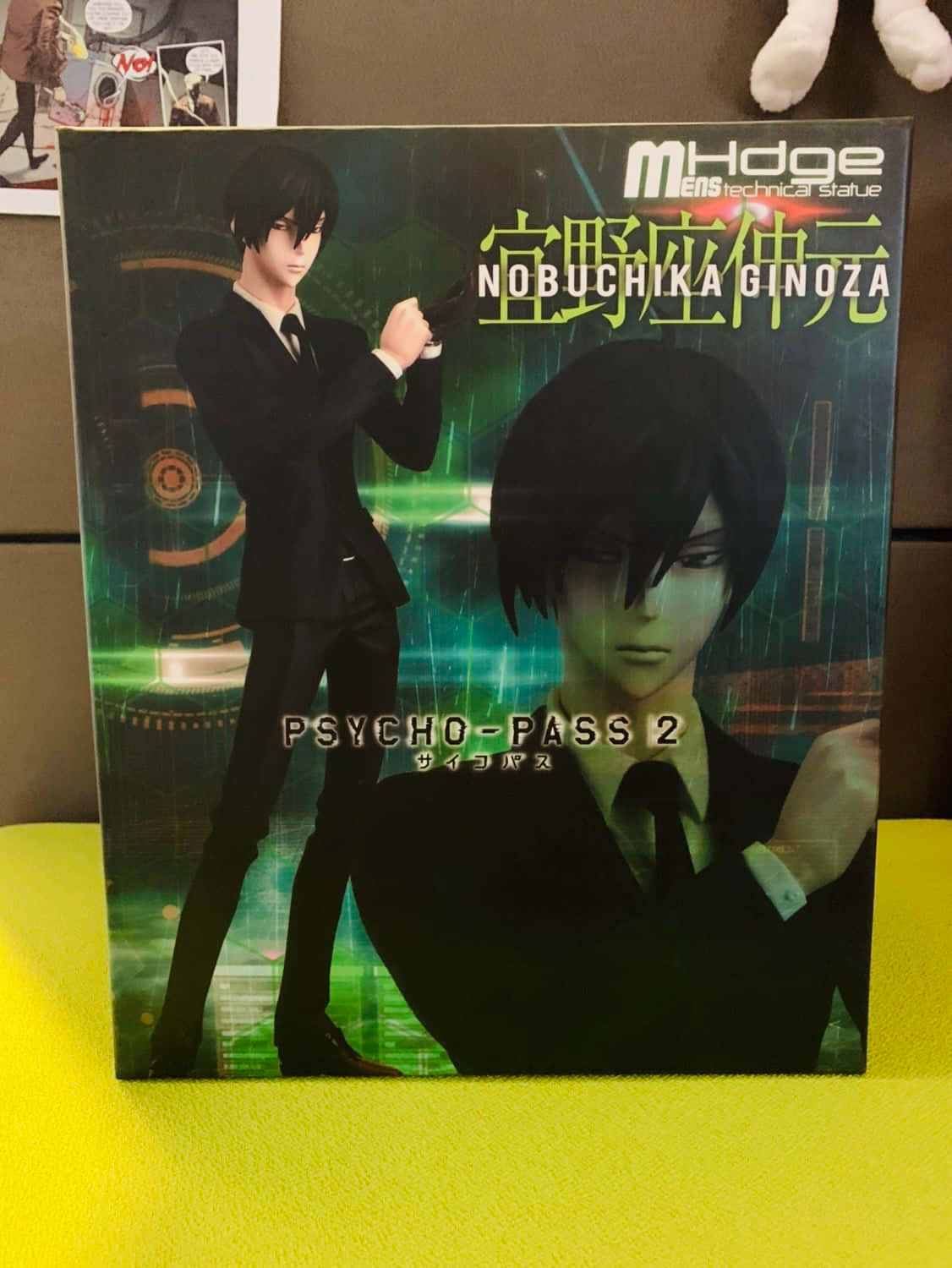 Nobuchika Ginoza 桌布 壁紙 — 一個《PSYCHO-PASS 2》動畫人偶盒， featuring 宜野座伸元身穿黑色西裝，在發光的綠色數碼背景前手持槍械。