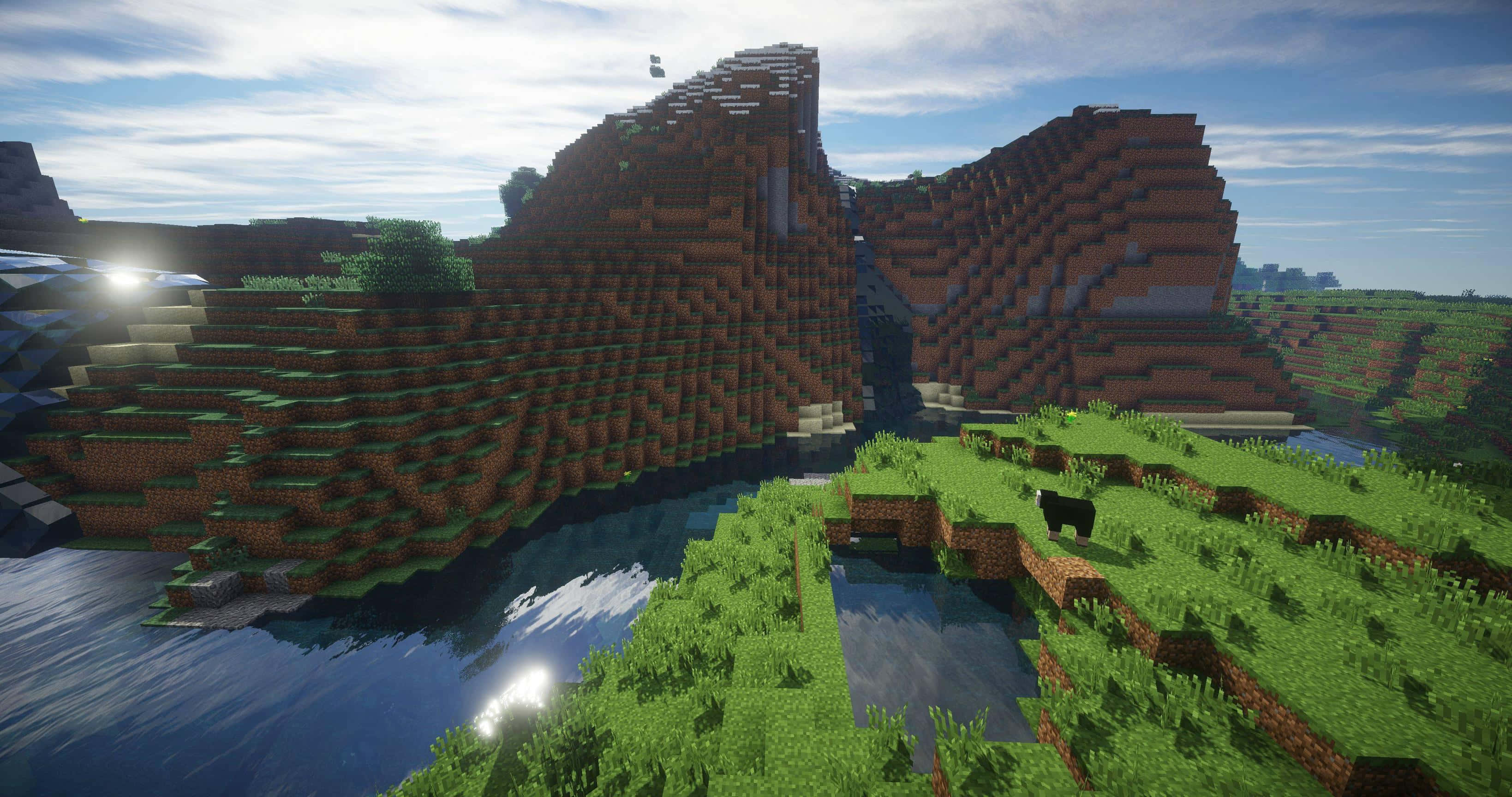 Minecraft Pocket Edition 桌布 壁紙 — 一個Minecraft景觀，有方塊狀的山脈、河流和一頭牛，在明亮的藍天下有蓬鬆的雲朵。