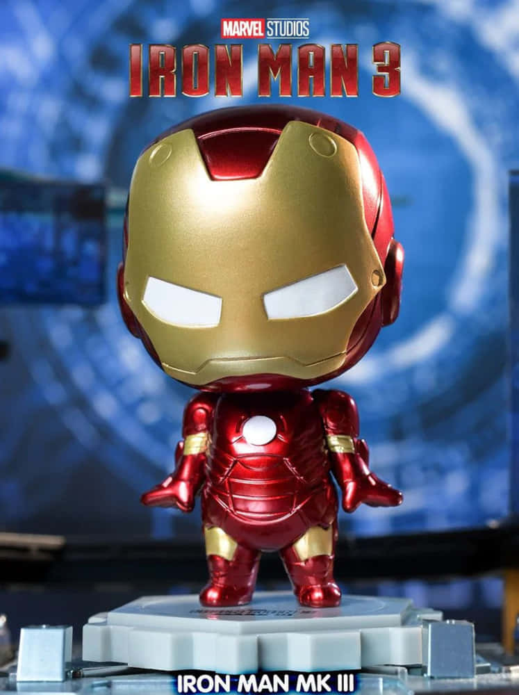 Iron Man Bobbleheads 桌布 壁紙 — 一個Q版風格的鐵甲奇俠MK III可動人偶站在灰色底座上，背景是藍色科技主題並帶有電影標題文字。