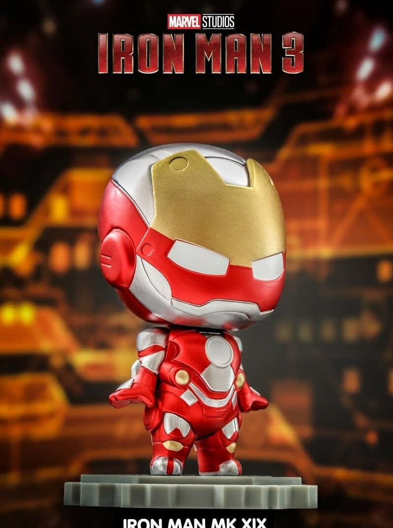 Iron Man Bobbleheads 桌布 壁紙 — 一個Q版風格的鐵甲奇俠MK XIX人偶自豪地站在底座上，背景是發光的未來城市景觀。