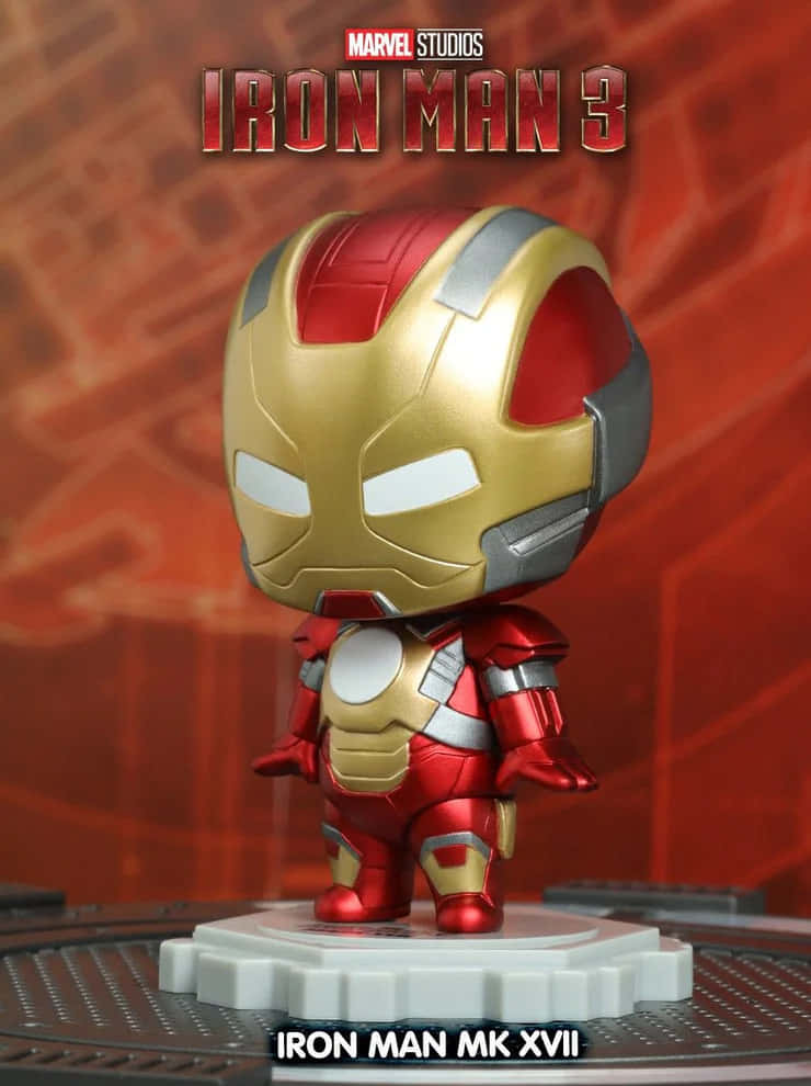 Iron Man Bobbleheads 桌布 壁紙 — 一個Q版風格的鐵甲奇俠MK XVII人偶站在齒輪底座上，背景是紅色科技主題和電影標題文字。