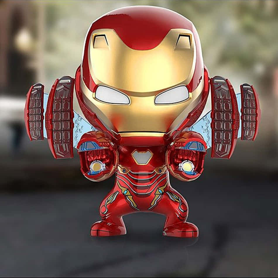Iron Man Bobbleheads 桌布 壁紙 — 一個Q版風格的鐵甲奇俠人偶，身穿紅色和金色裝甲，帶有發光的斥力炮和半透明翅膀，背景模糊。
