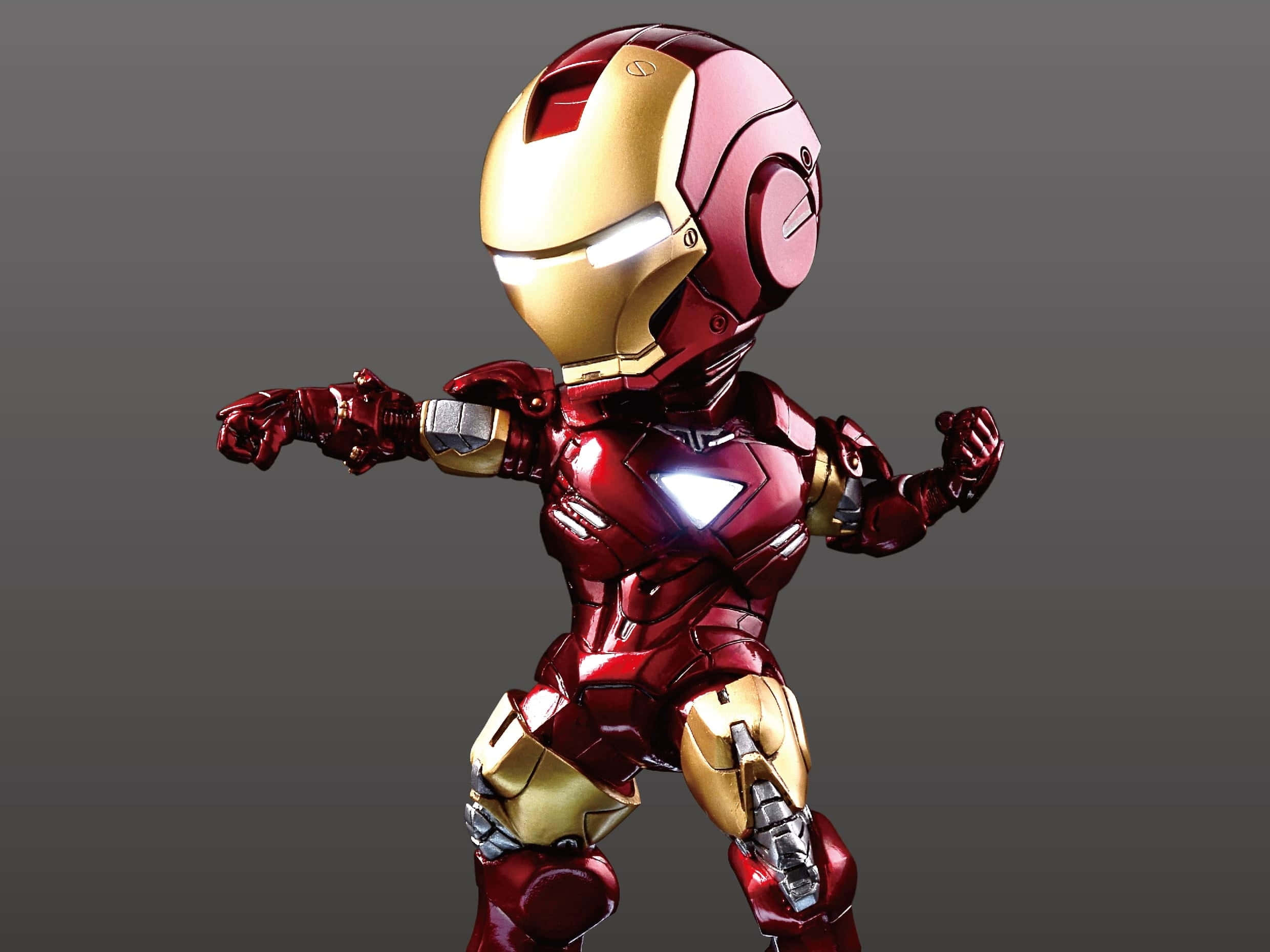 Iron Man Action Figures 桌布 壁紙 — 一個Q版風格的鐵甲奇俠人偶，身穿紅色和金色裝甲，在純灰色背景上動態地站立。