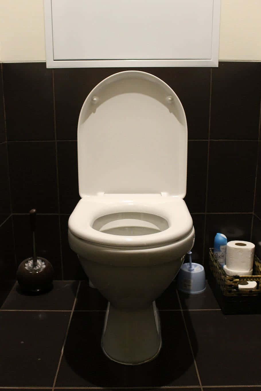 Toilet 桌布 壁紙 — 一個乾淨的白色馬桶，蓋子打開，位於現代浴室中，牆壁和地板是黑色瓷磚。