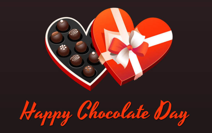 Chocolate Day 桌布 壁紙 — 一個亮面紅色心形朱古力盒，配有白色絲帶，內有各式朱古力，背景深色，並有「Happy Chocolate Day」文字。